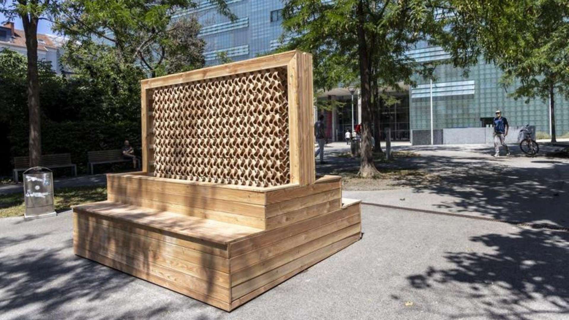 Große Bank aus Holz mit durchbrochener keramischer Rückwand in einem Park.
