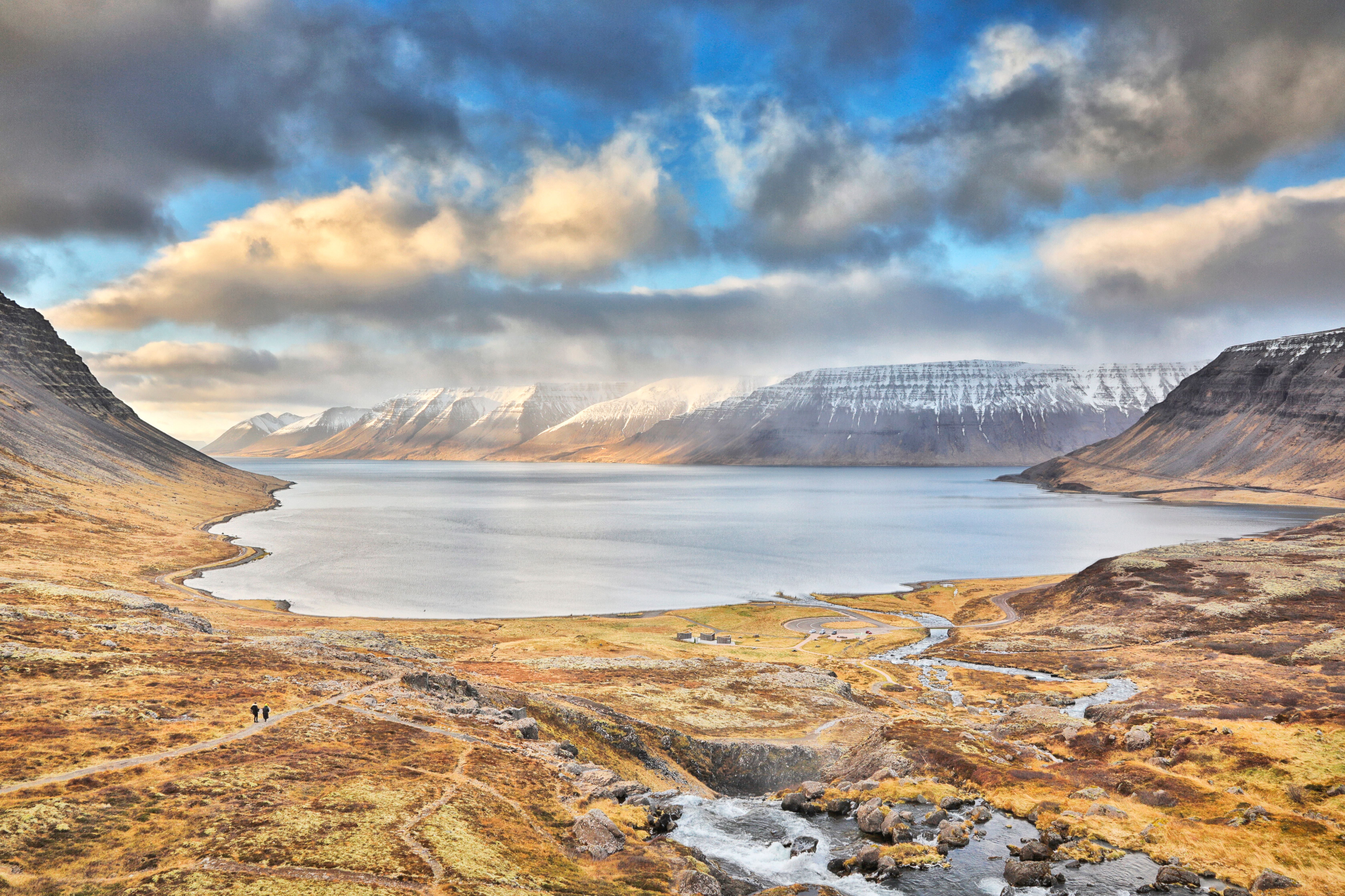 Weitläufige Herbstlandschaft mit Fjord, Bergen und Dynjandi-Wasserfall in Island.