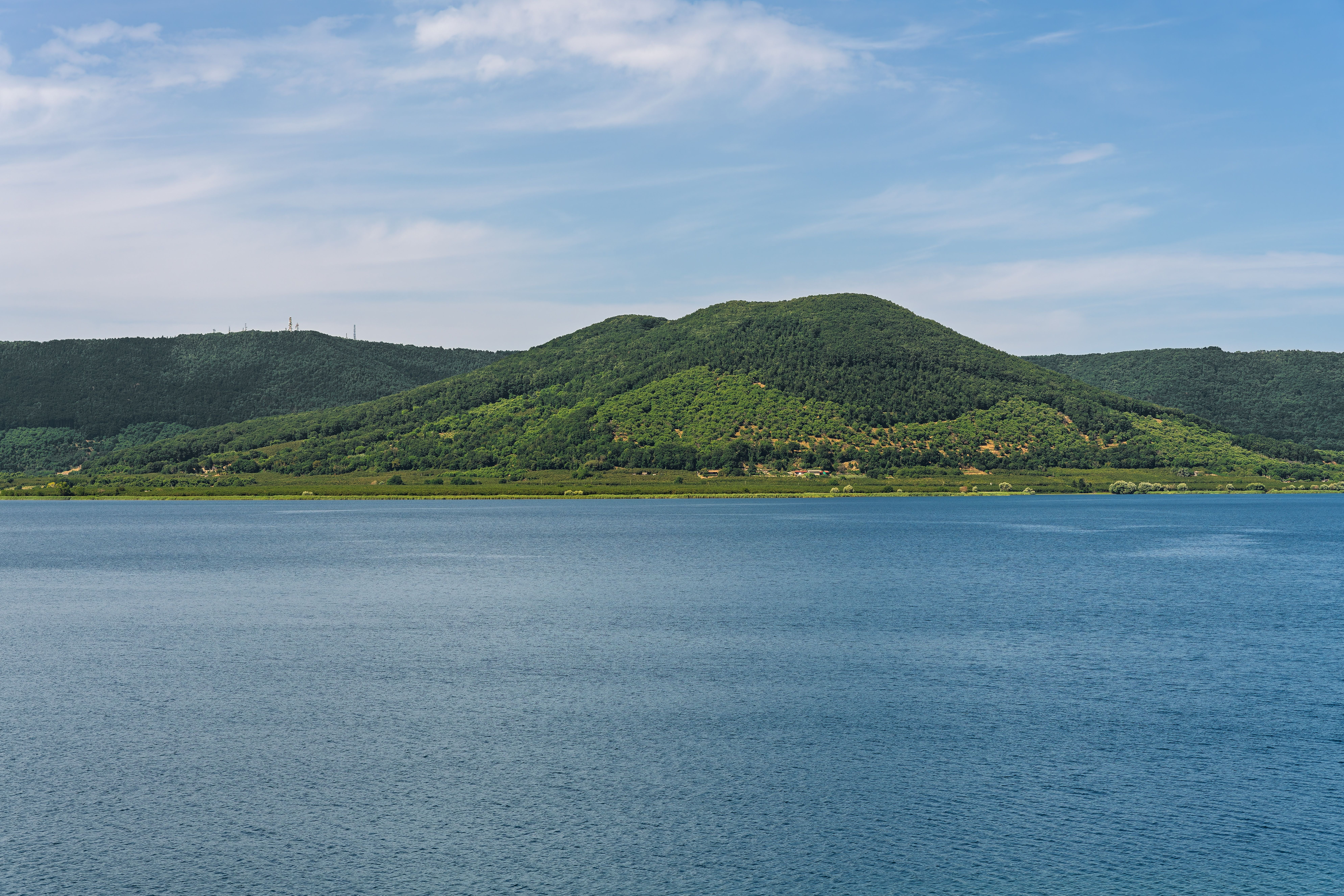Vulkanischer Kratersee Lago di Vico in Italien, umgeben von bewaldeten Hügeln und blauem Wasser.