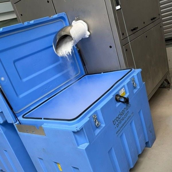 Ein blauer Trockeneisbehälter wird durch ein vereistes Rohr befüllt.