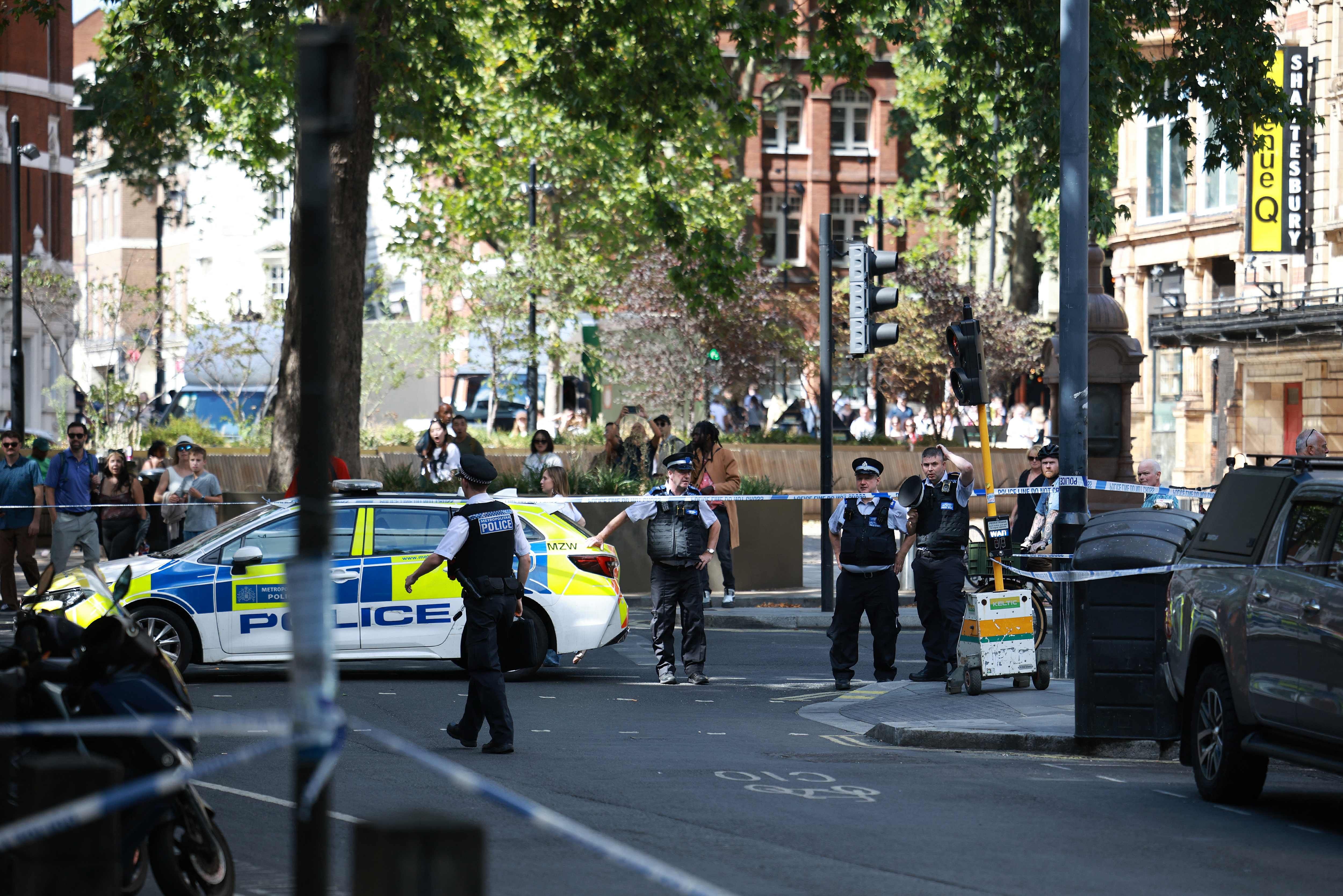 Polizisten sperren eine Straße in Covent Garden, London, mit Polizeiabsperrung und Einsatzfahrzeug ab.