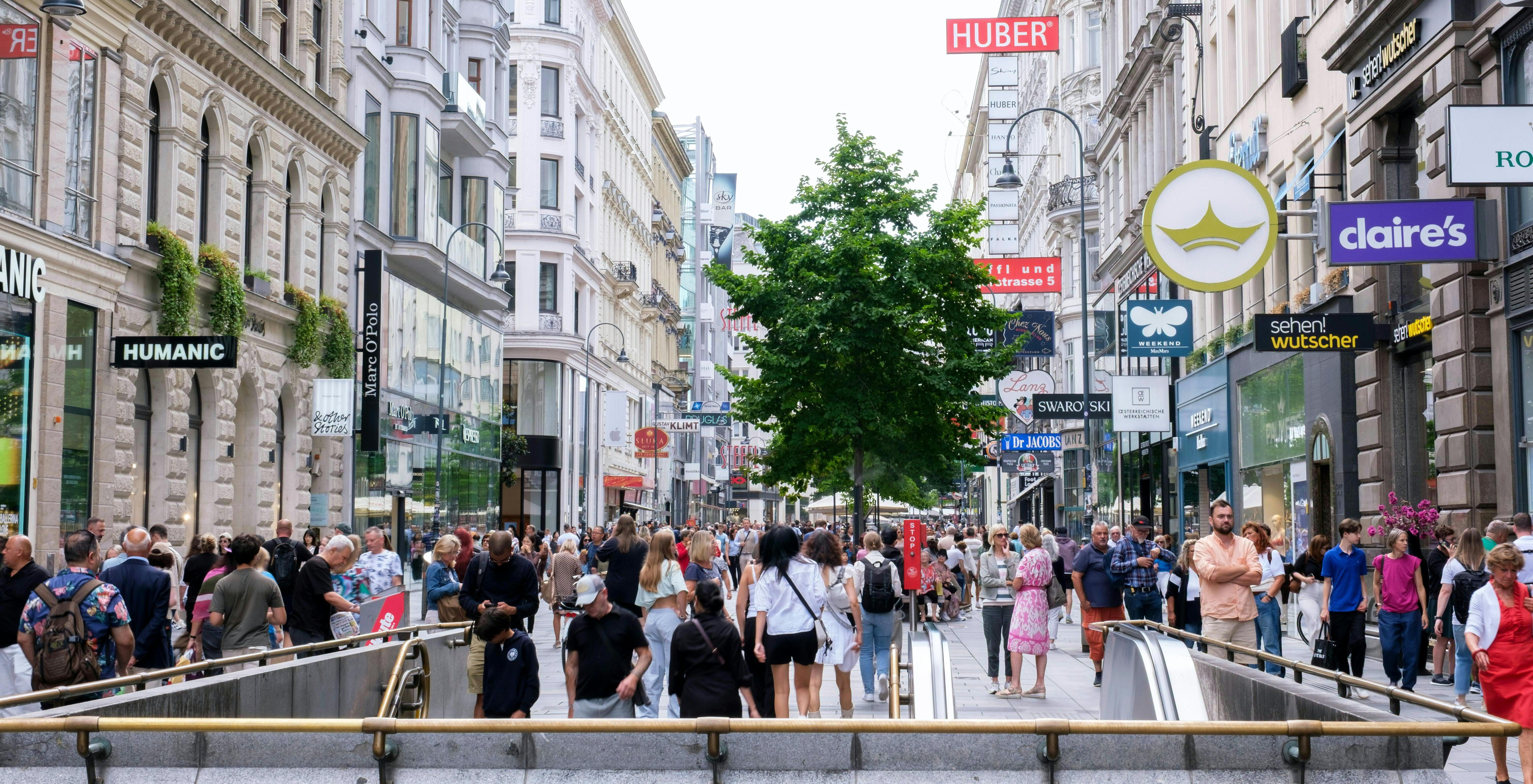 Viele Menschen spazieren und shoppen auf der belebten Kärntner Straße in Wien im Sommer.