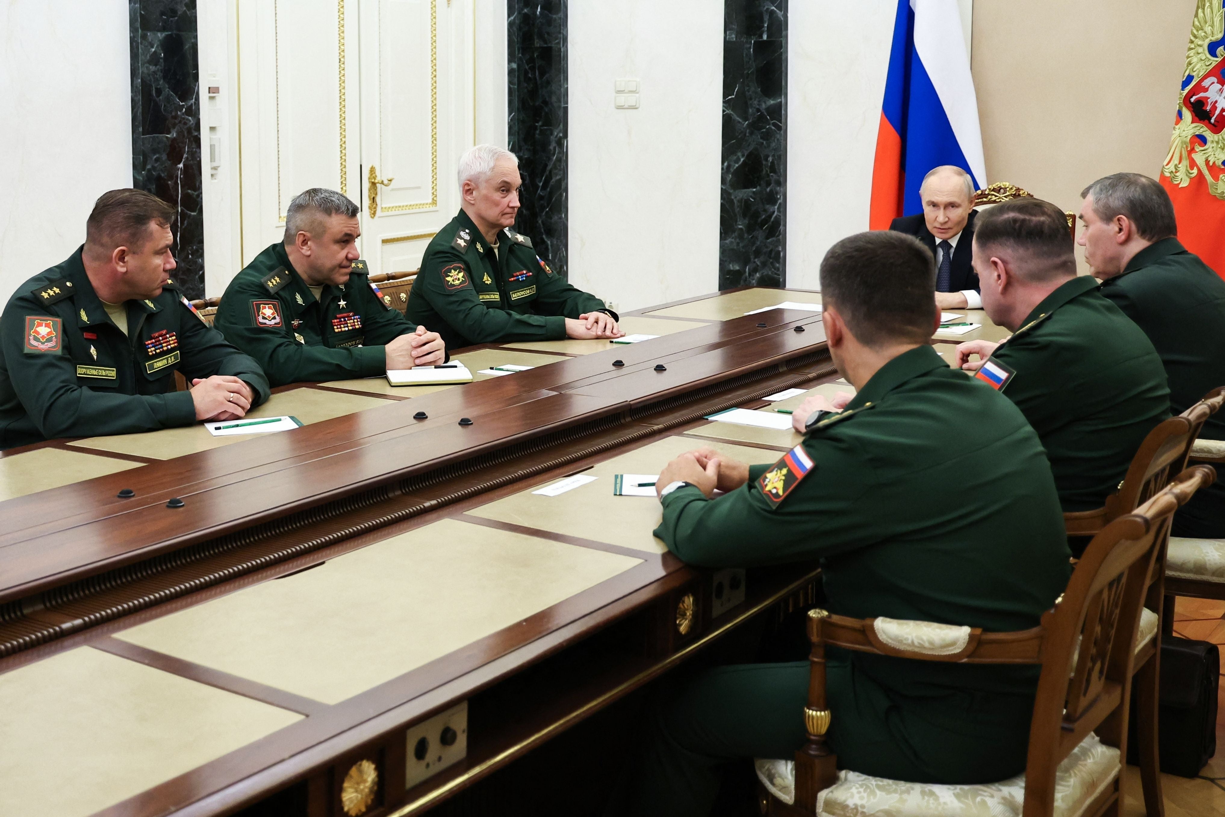 Der russische Präsident trifft sich mit Militärführung an einem langen Konferenztisch in Moskau.