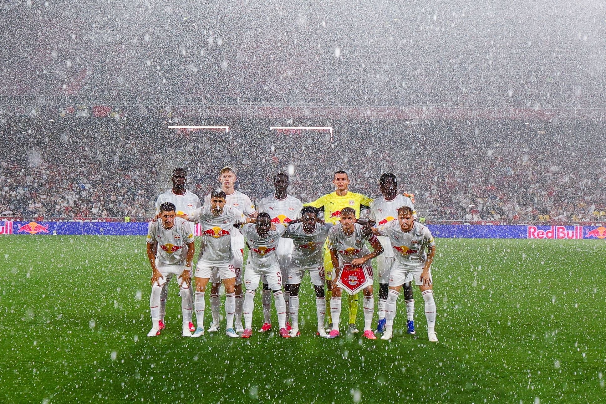 Das Team von Red Bull Salzburg posiert im strömenden Regen vor dem Spiel für ein Mannschaftsfoto.