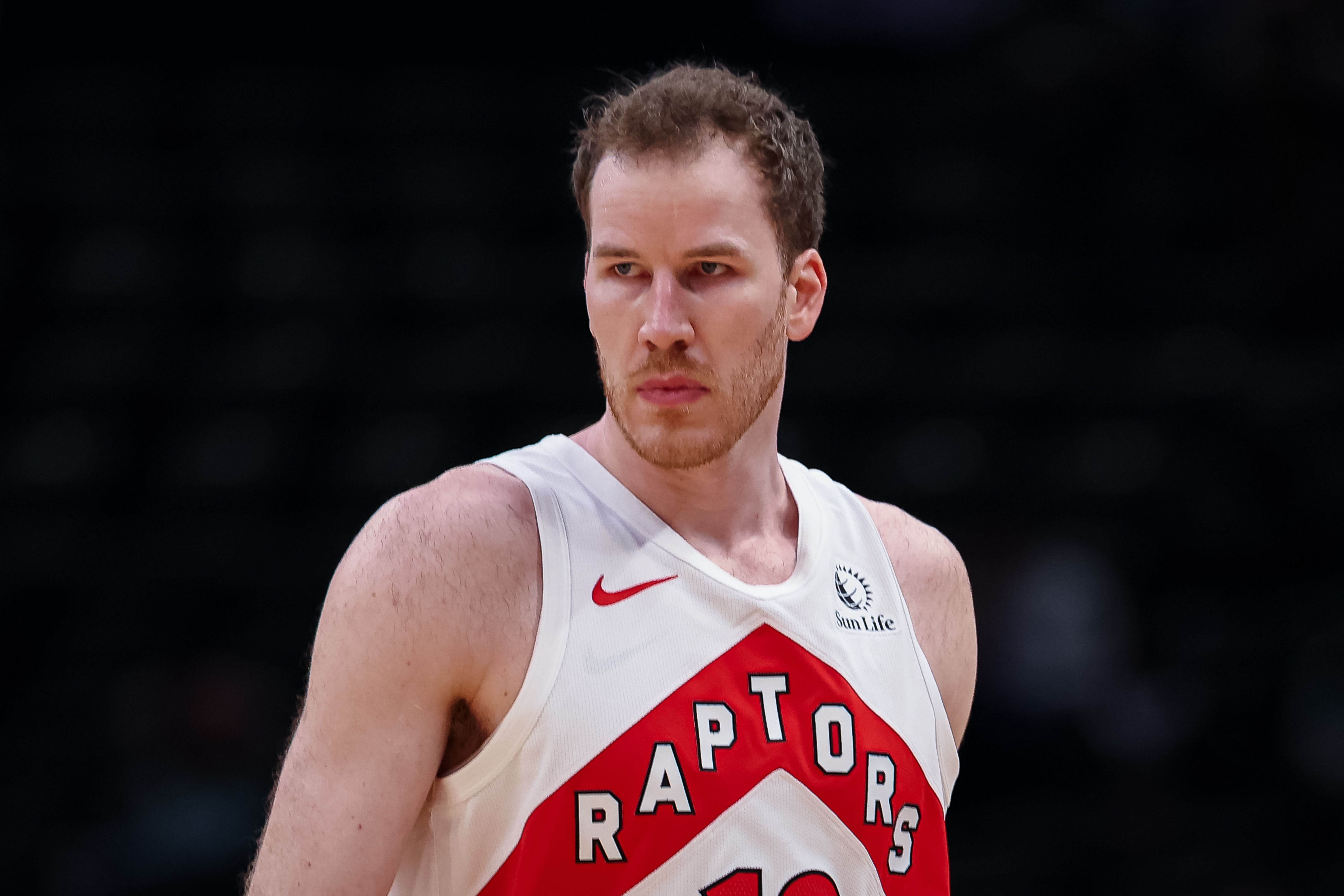 Ein Basketballspieler der Toronto Raptors im weißen Trikot blickt ernst zur Seite.