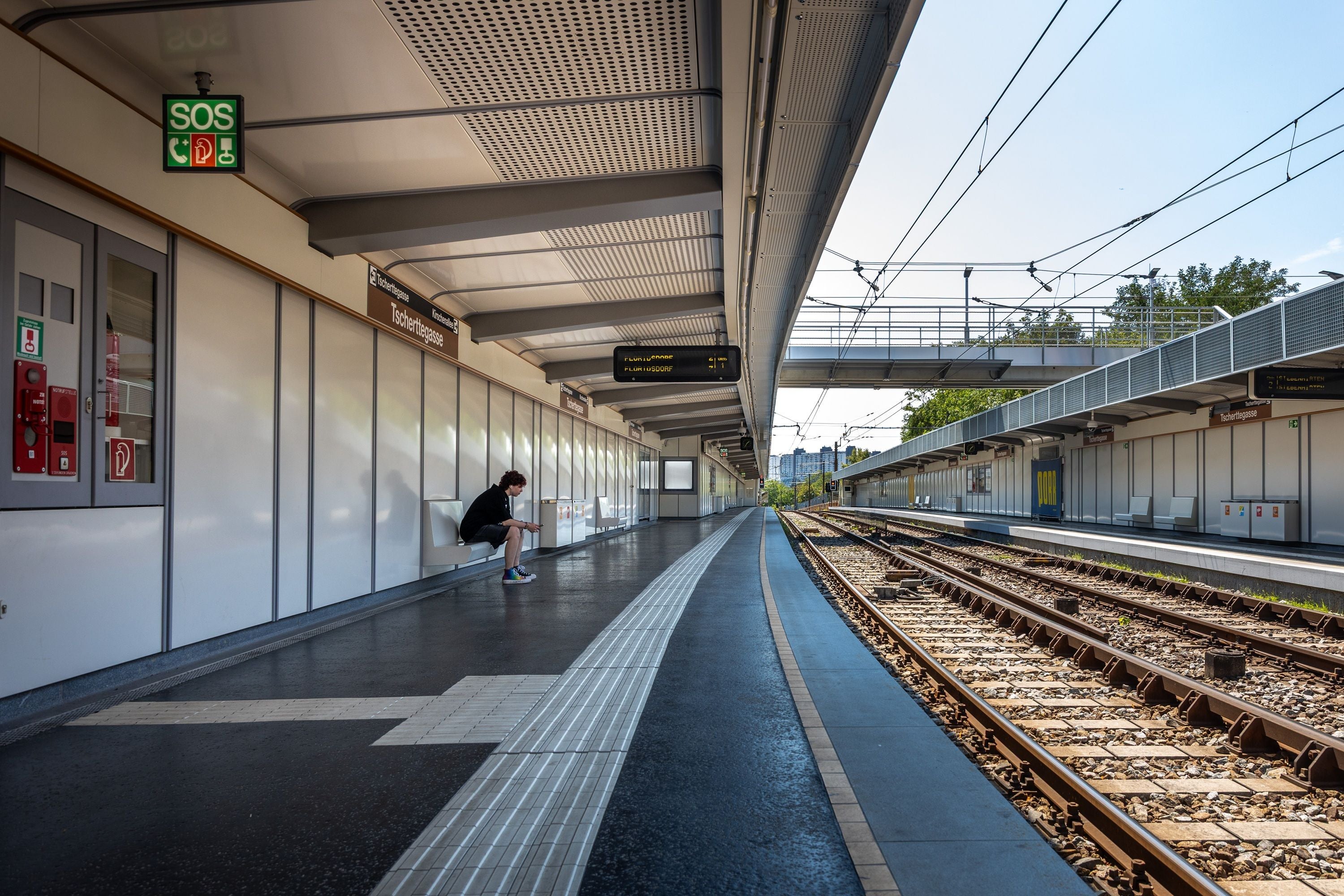 Leere U-Bahn-Station Tscherttegasse mit einer sitzenden Person auf der Bank am Bahnsteig.