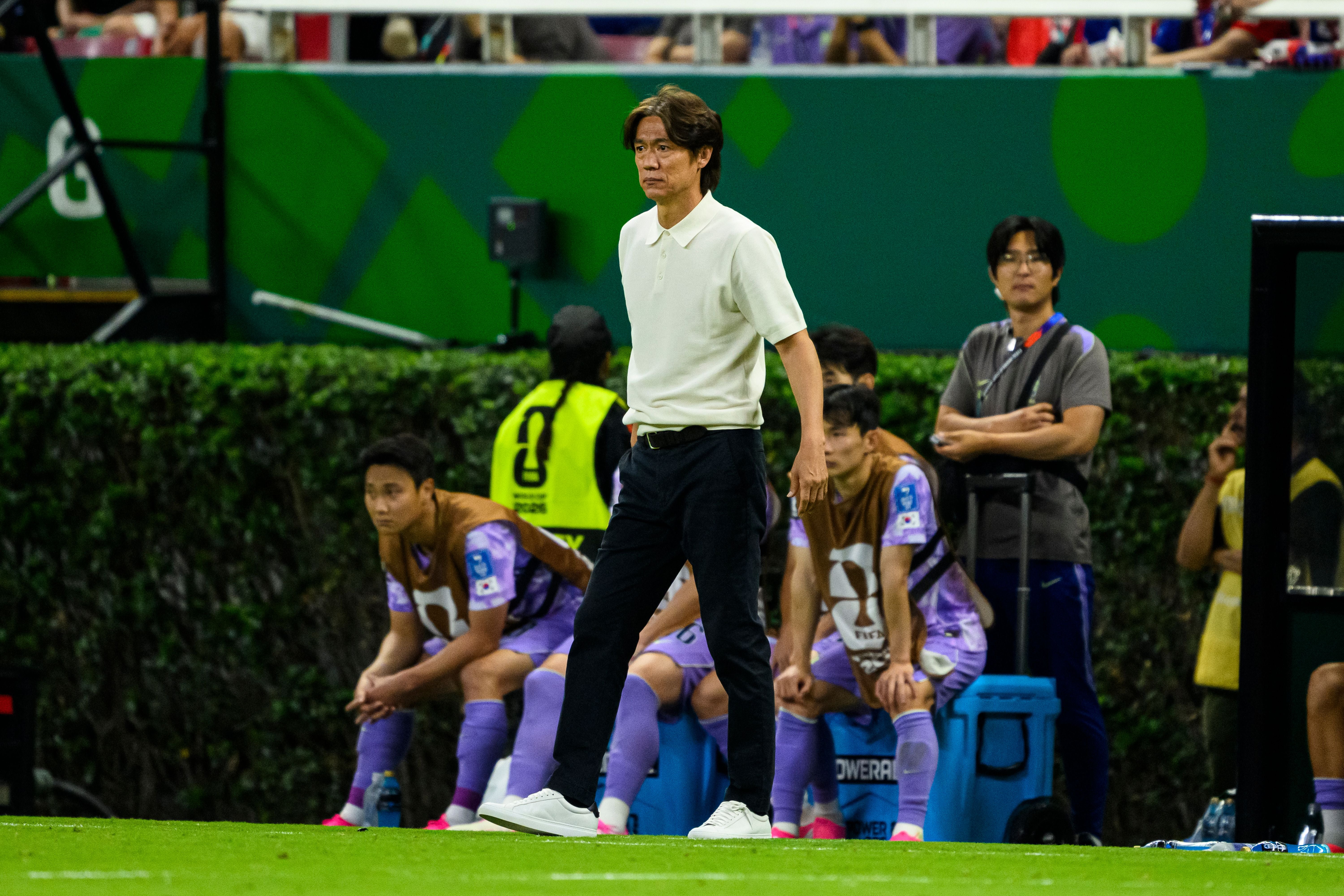 Trainer Myungbo Hong steht am Spielfeldrand, im Hintergrund sitzt die südkoreanische Ersatzbank.