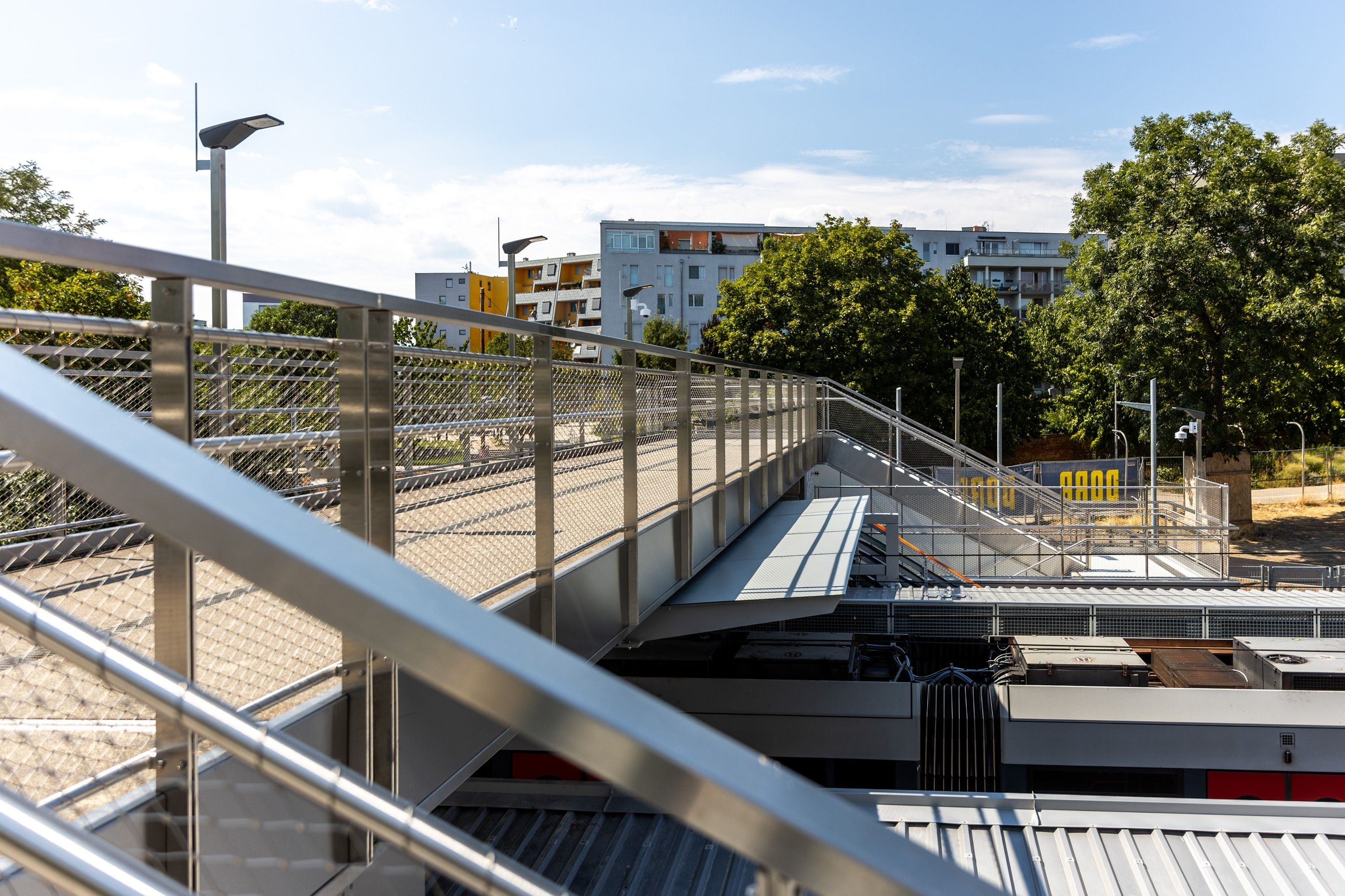 Moderne Fußgängerbrücke mit Geländer an der renovierten U6-Station Tscherttegasse.