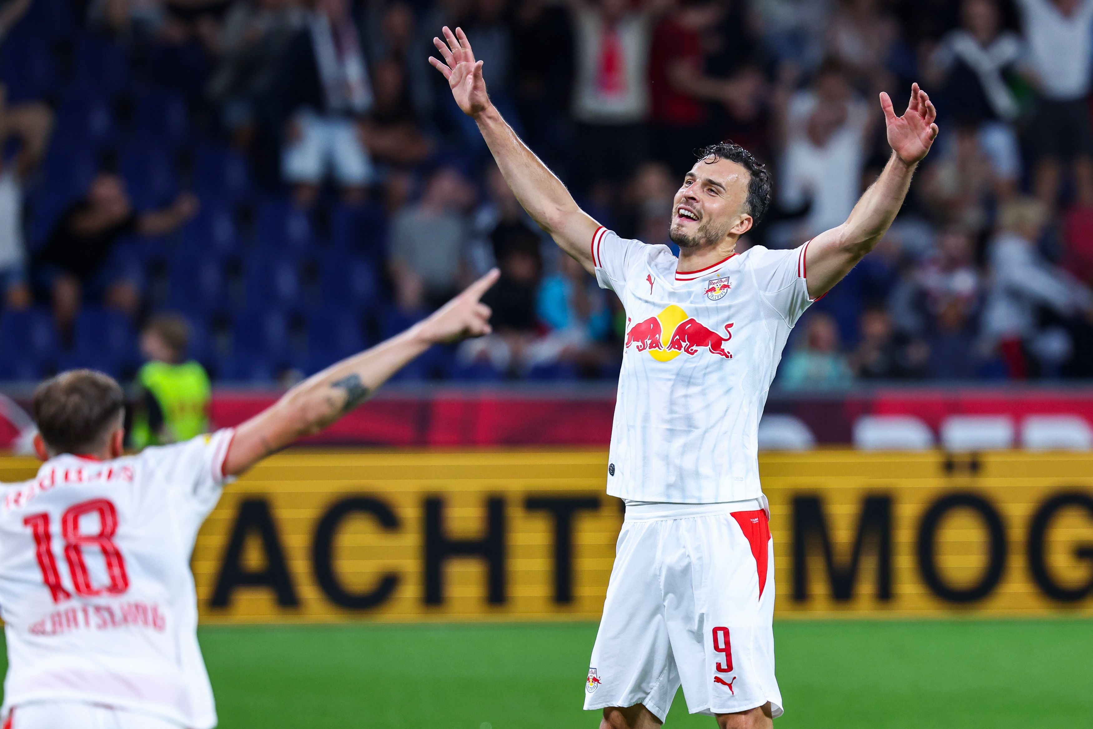 Ein Fußballspieler von Red Bull Salzburg jubelt mit erhobenen Armen nach einem Tor.