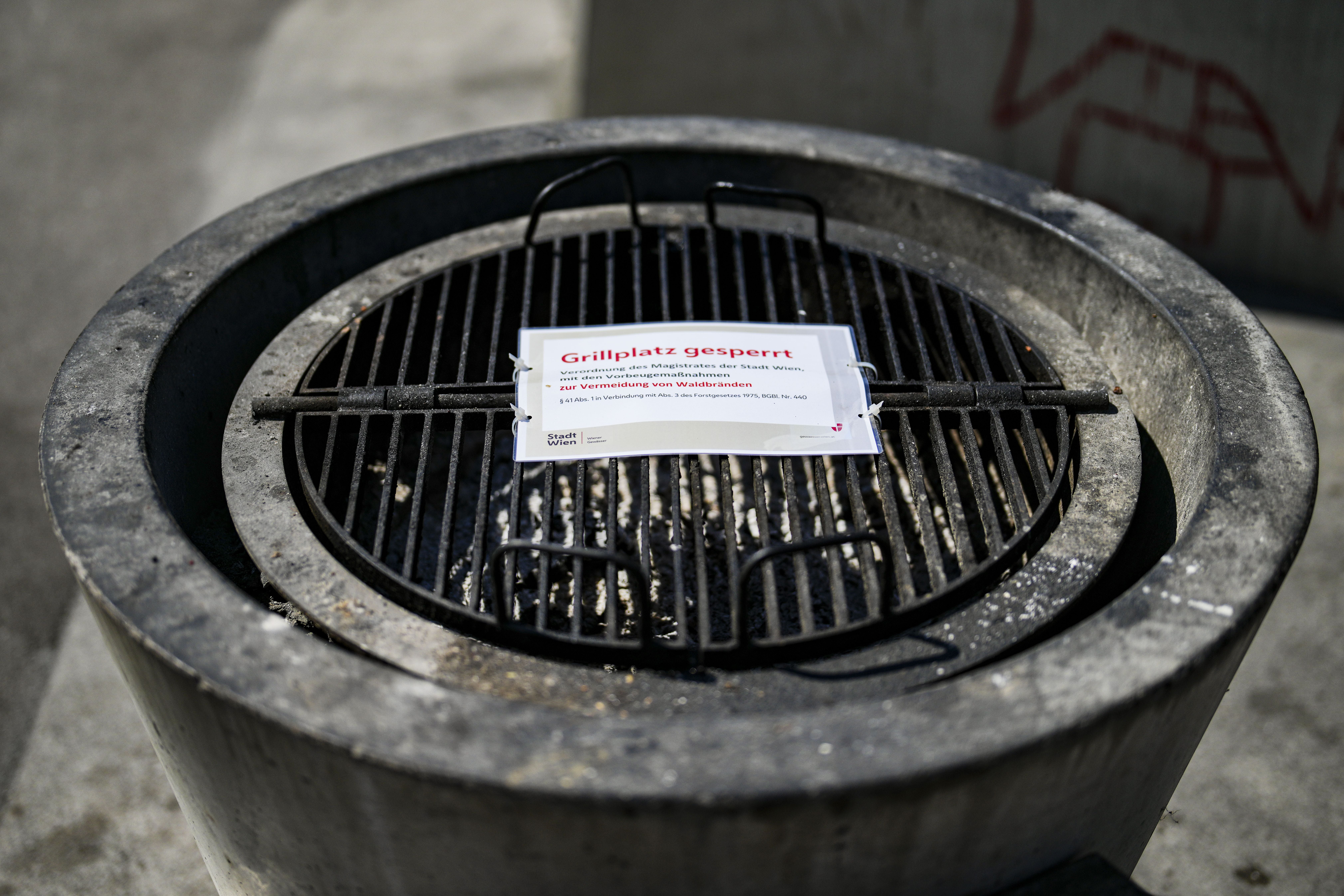 Geschlossener Grillplatz auf der Donauinsel mit Schild "Grillplatz gesperrt" am Grillrost befestigt.