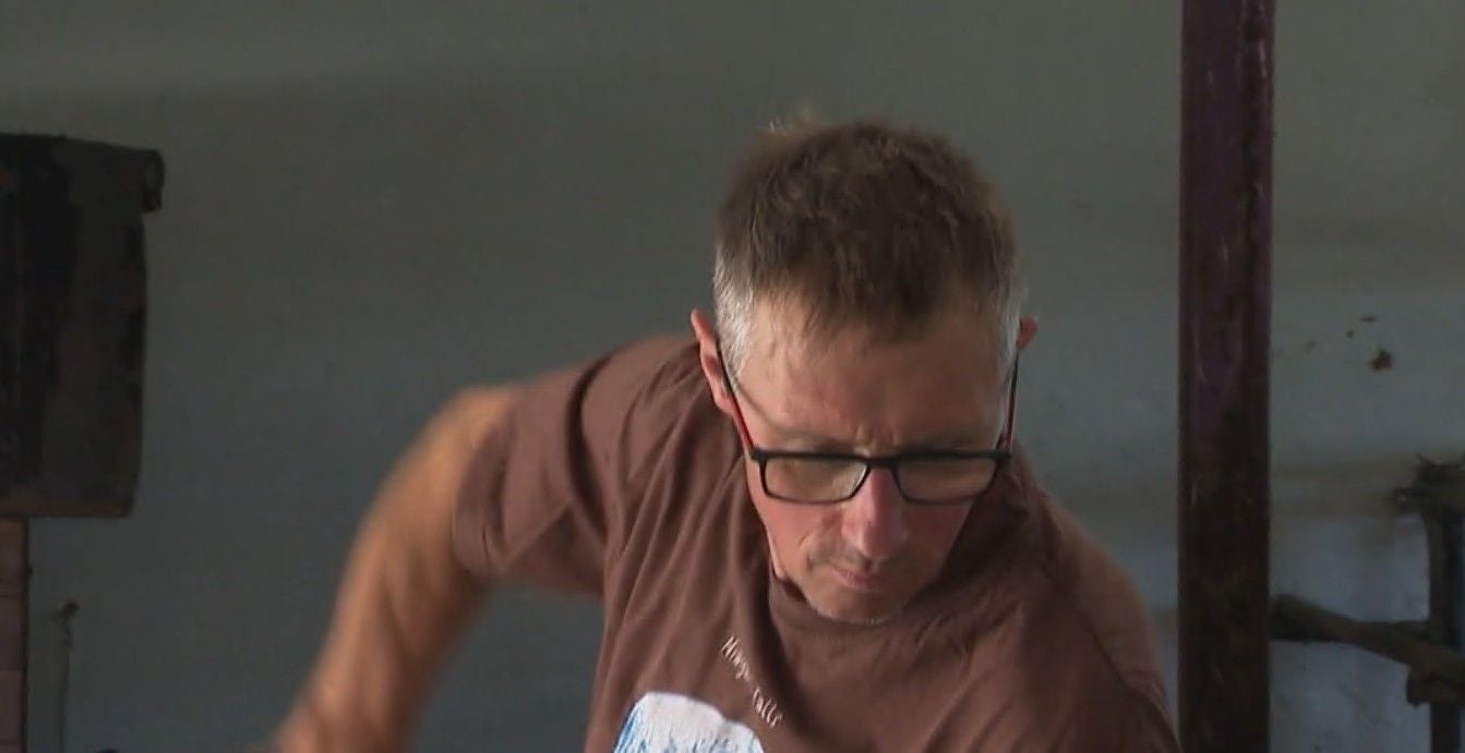 Ein Mann mit Brille arbeitet konzentriert, trägt ein braunes T-Shirt.