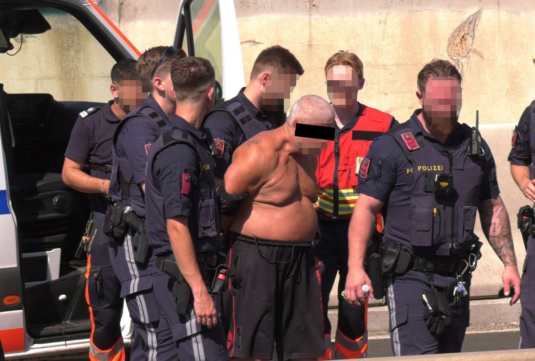 Polizisten nehmen einen oberkörperfreien Mann auf der Ostautobahn fest.