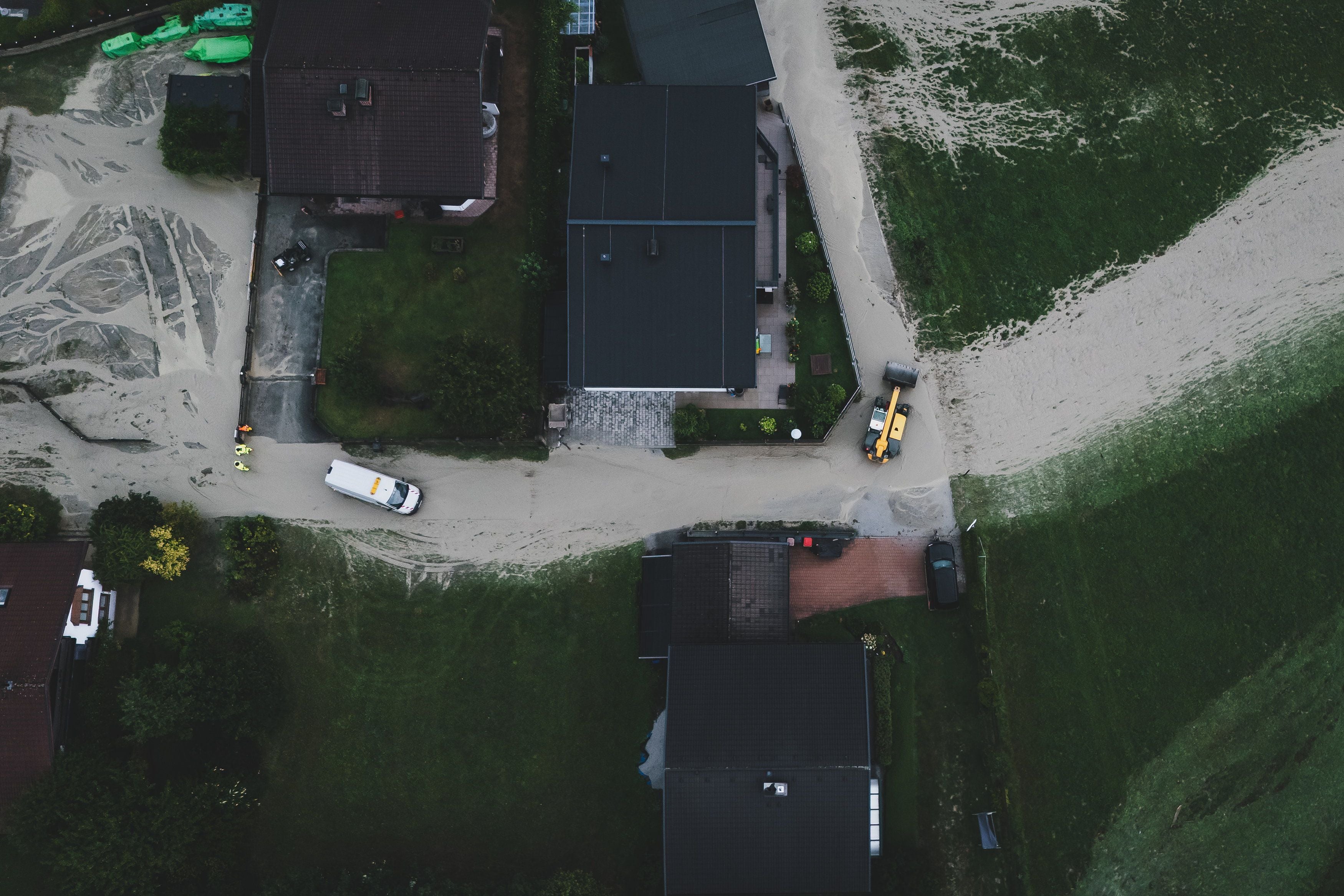 Luftaufnahme von überfluteten und verschlammten Straßen nach Hochwasser in Uttendorf, Österreich.