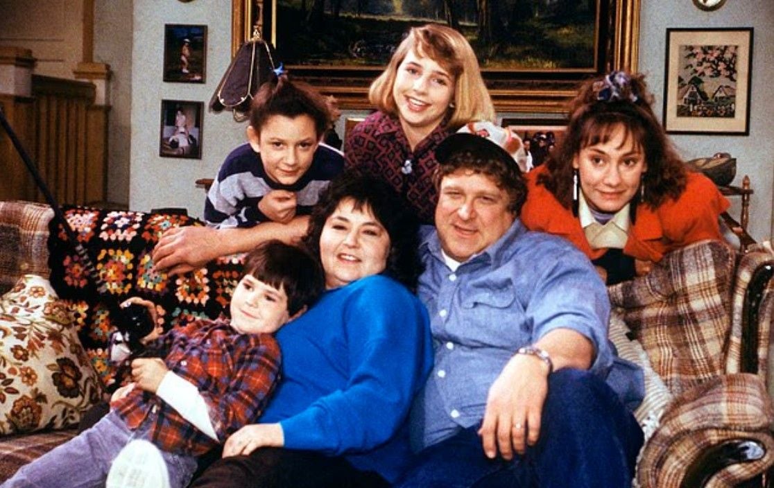 Im Uhrzeigersinn, von unten rechts: John Goodman, Roseanne Barr, Michael Fishman, Sara Gilbert, Lecy Goranson und Laurie Metcalf in der Originalserie von Roseanne.