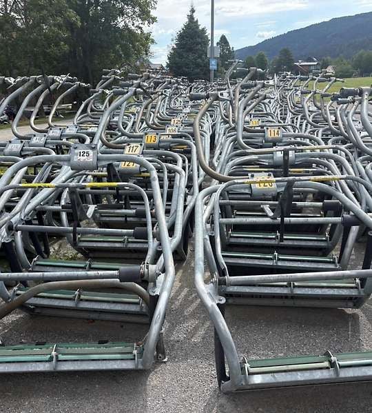 Viele demontierte Sessellift-Sitze stehen nummeriert auf einem Parkplatz am Kreischberg.