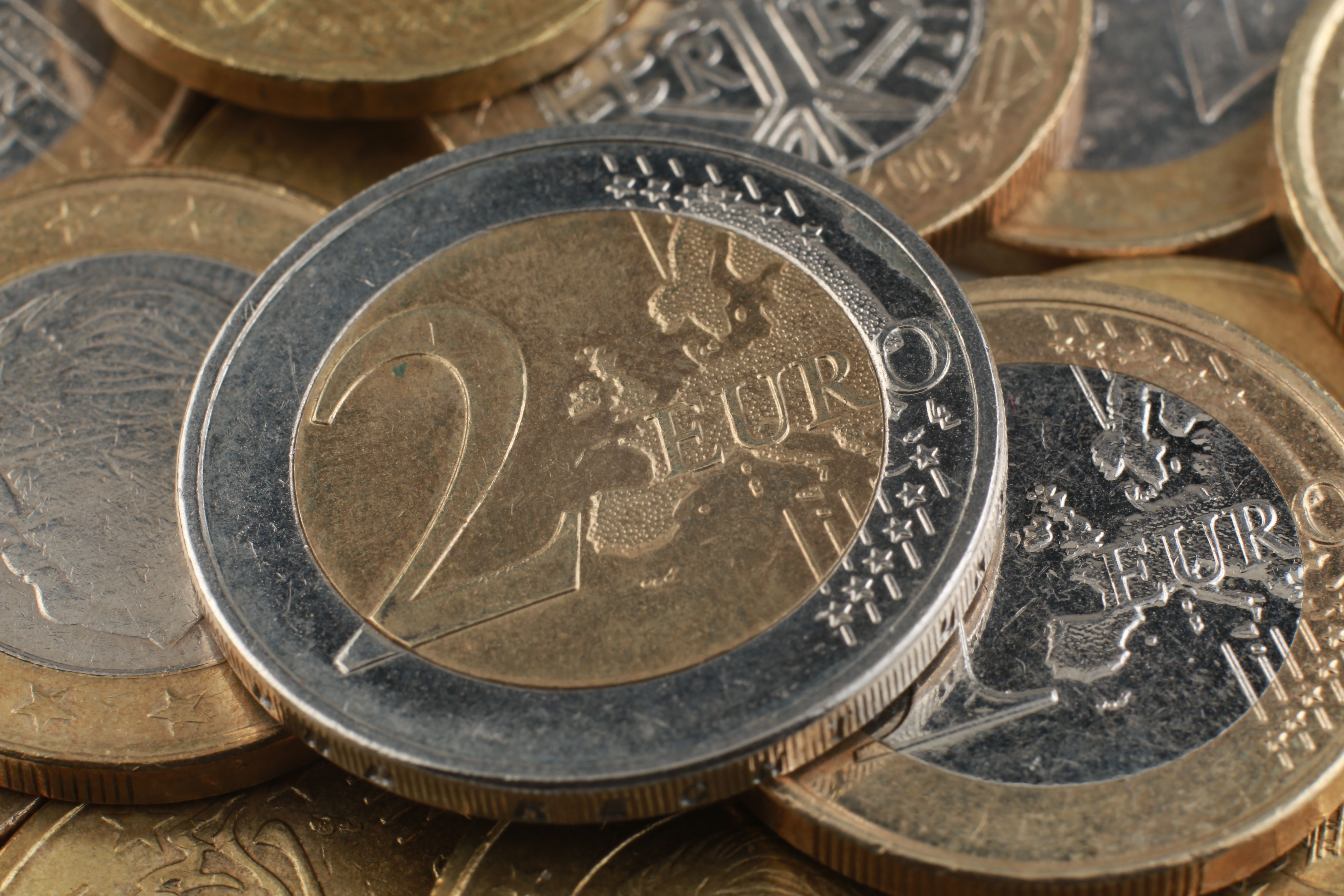 Mehrere gestapelte Zwei-Euro-Münzen liegen dicht beieinander.