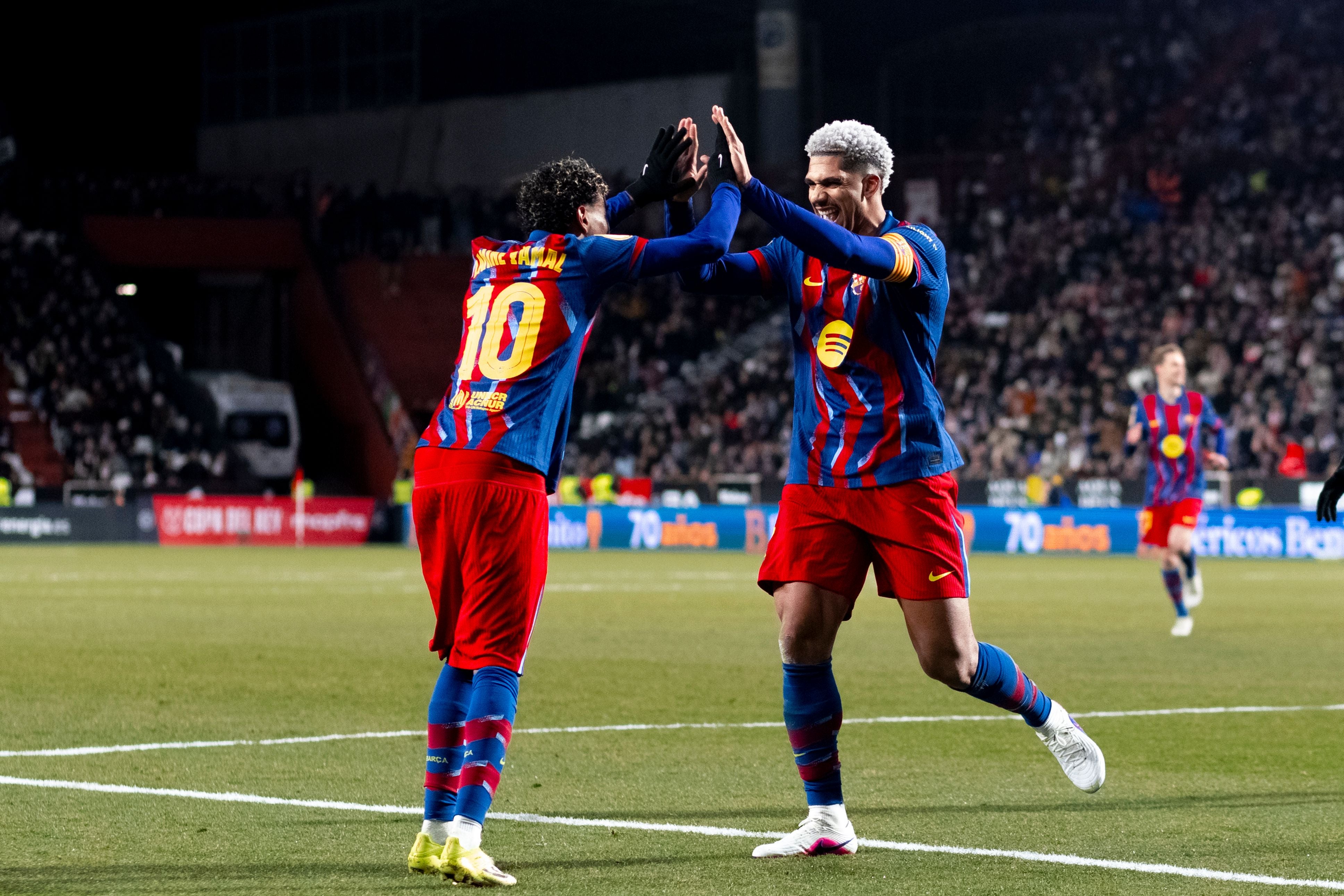 Zwei Fußballspieler im Barcelona-Trikot jubeln auf dem Spielfeld mit einem High-Five.