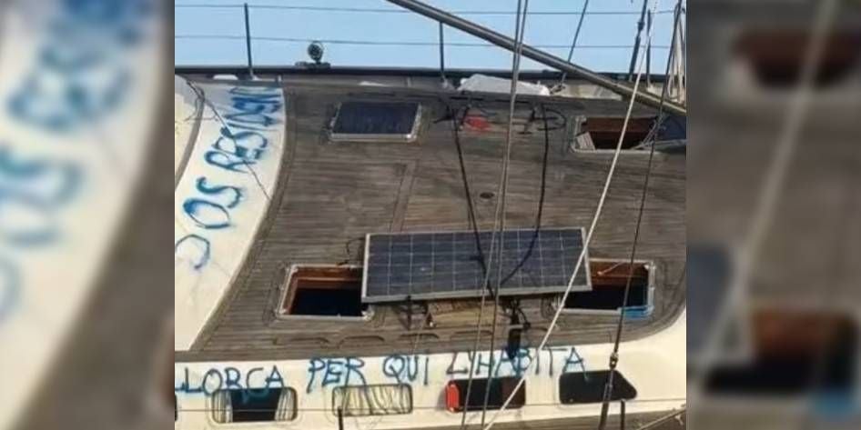 Oberdeck eines Segelbootes mit Graffiti in blauer Schrift und einem Solarpanel.
