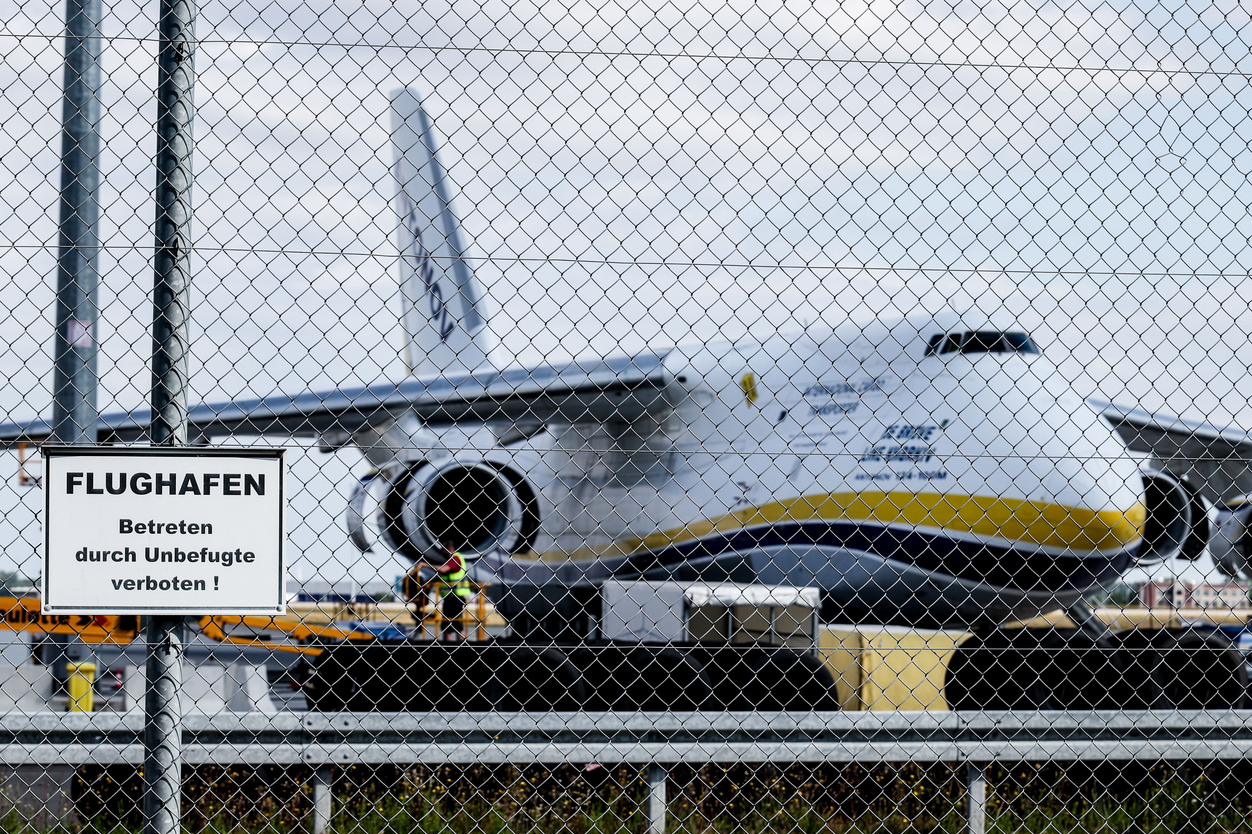 Ein ukrainisches Frachtflugzeug steht hinter einem Sicherheitszaun am Flughafen Leipzig-Halle.