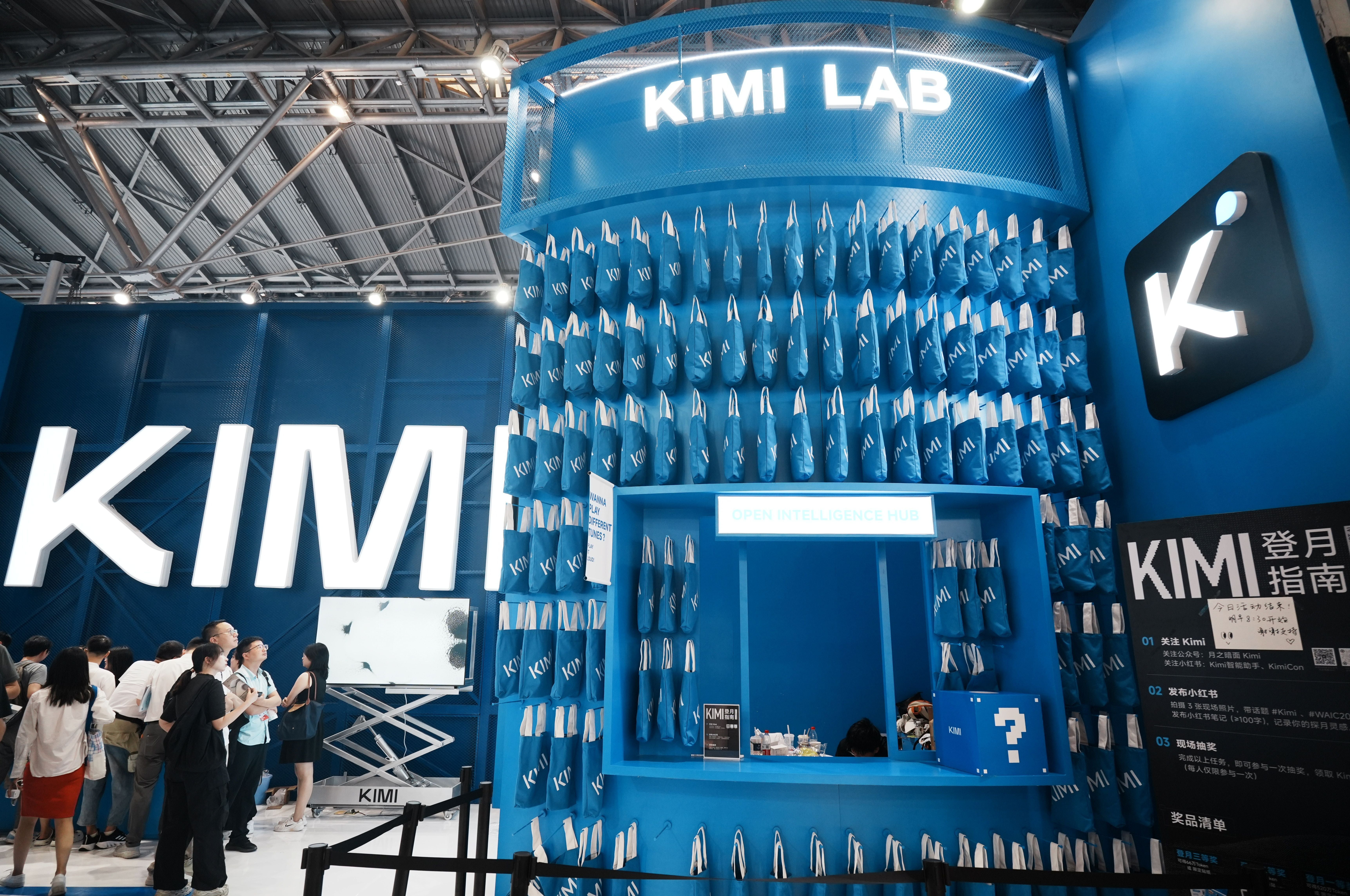 Menschen besuchen den Kimi-Messestand mit vielen blauen Taschen auf der World AI Conference in Shanghai.