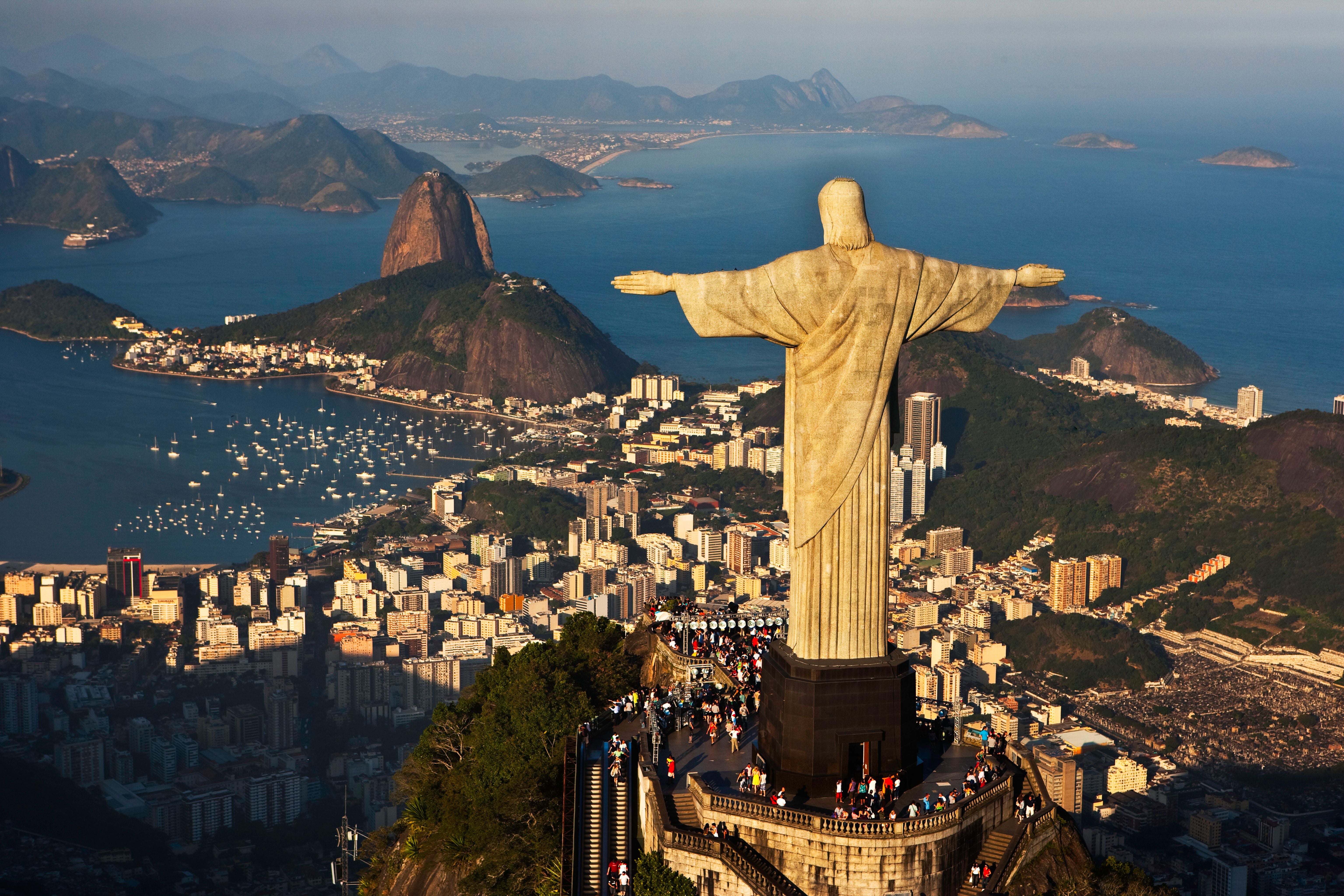 Die Christusstatue überblickt Rio de Janeiro mit Meer, Bergen und Stadt im Hintergrund.