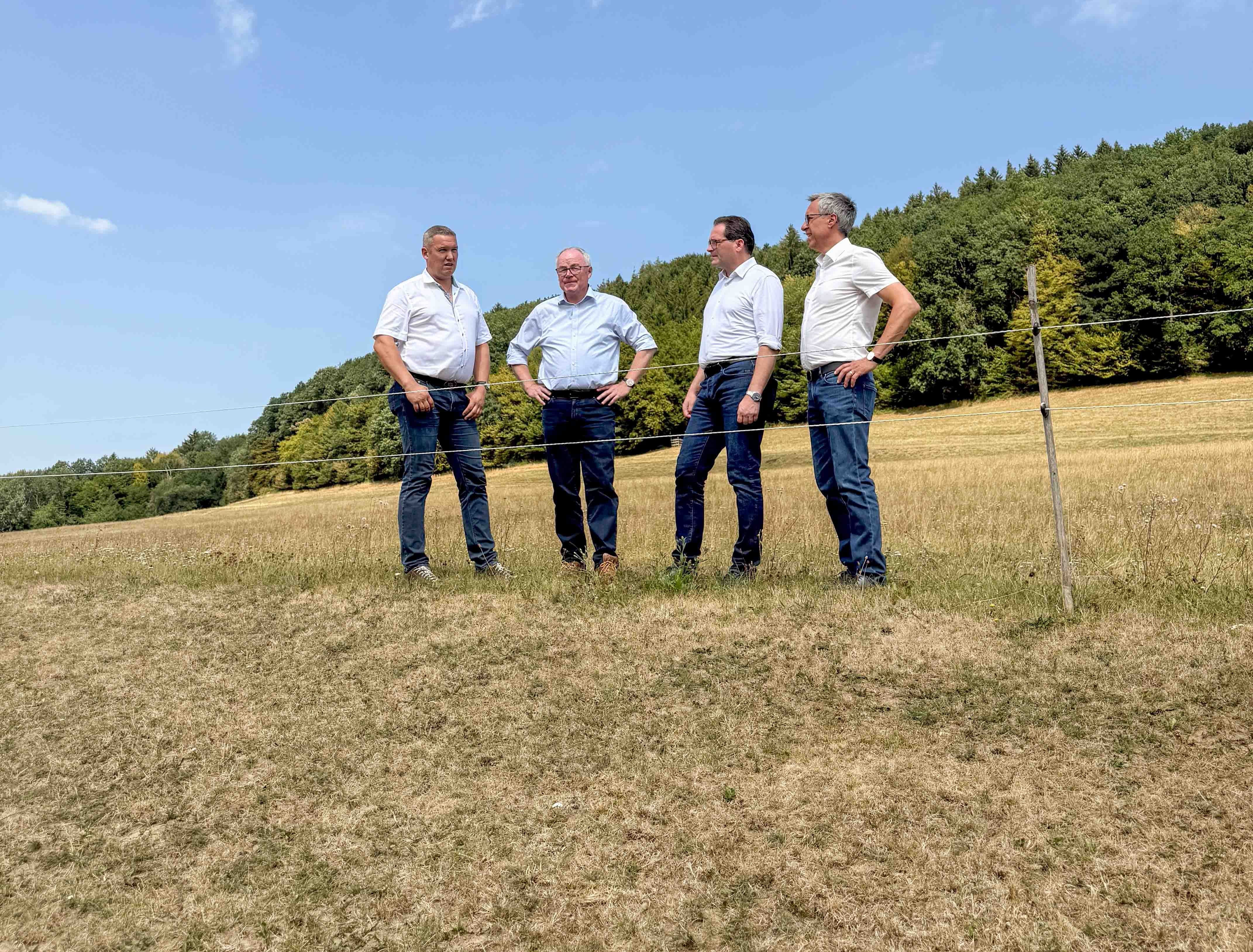 Extreme Dürre: Landwirtschaftsminister Norbert Totschnig steht bei einer Hofbesichtigung vor einer vertrockneten Wiese. Die historische Trockenheit setzt die Landwirtschaft massiv unter Druck.