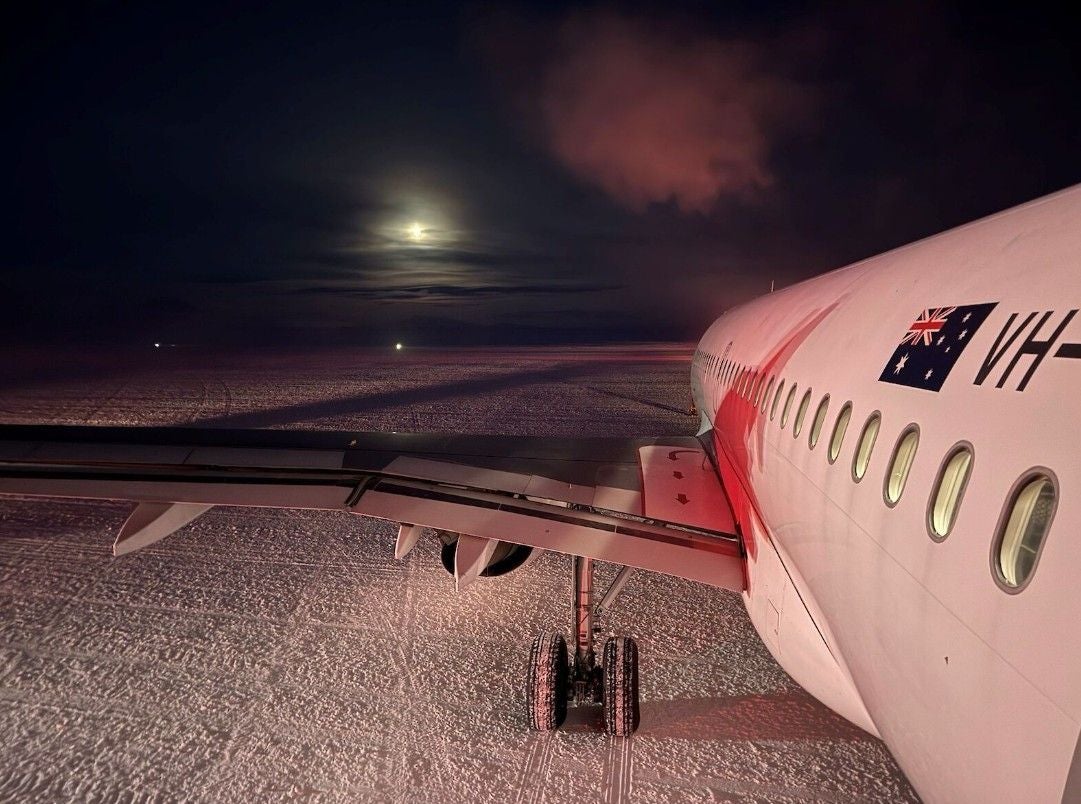 Nachtaufnahme des Rettungseinastzes auf schneebedeckter Landebahn in der Antarktis mit Mond am Himmel.