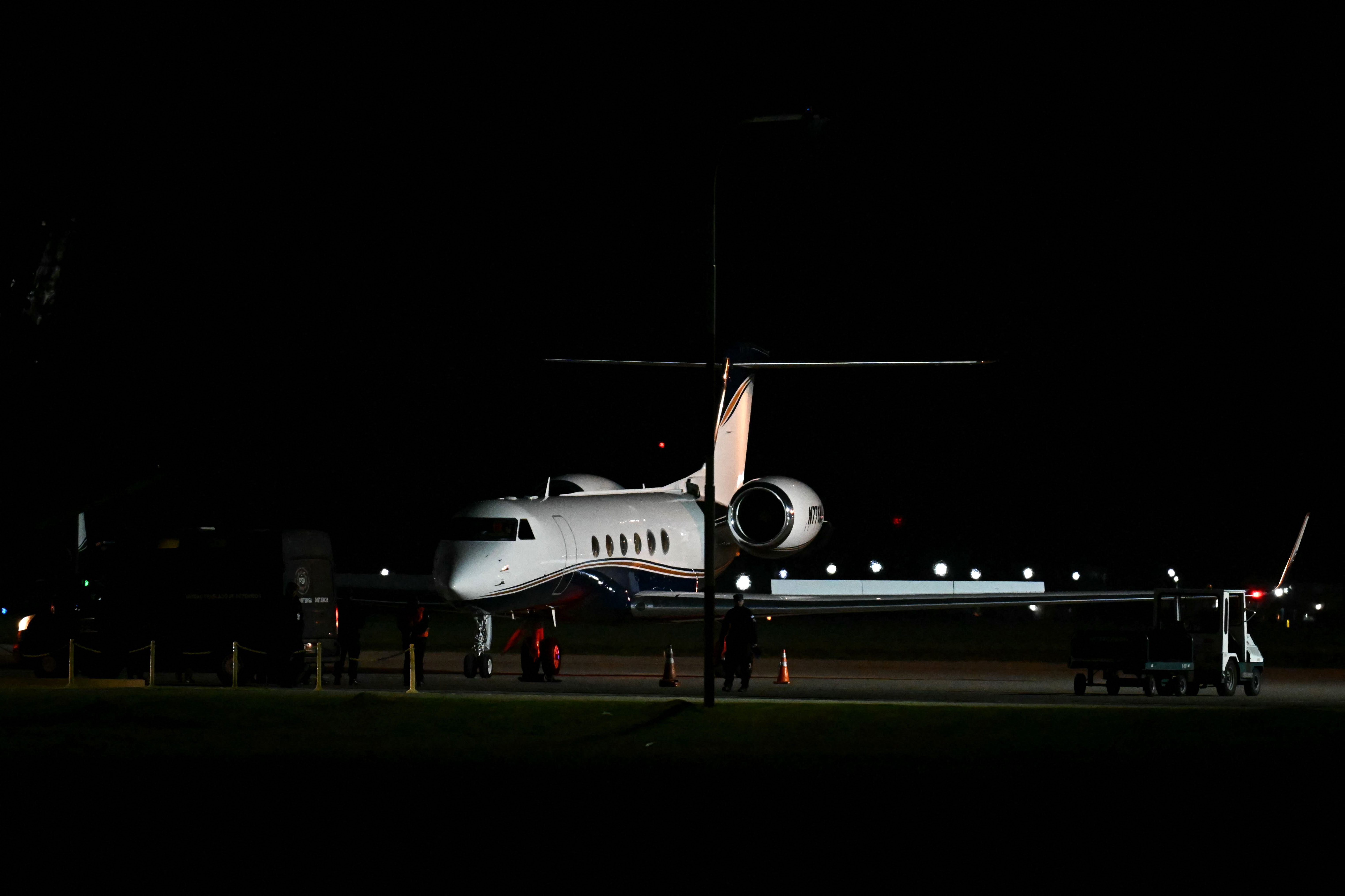 Ein Privatjet steht nachts auf einem beleuchteten Rollfeld eines Flughafens.