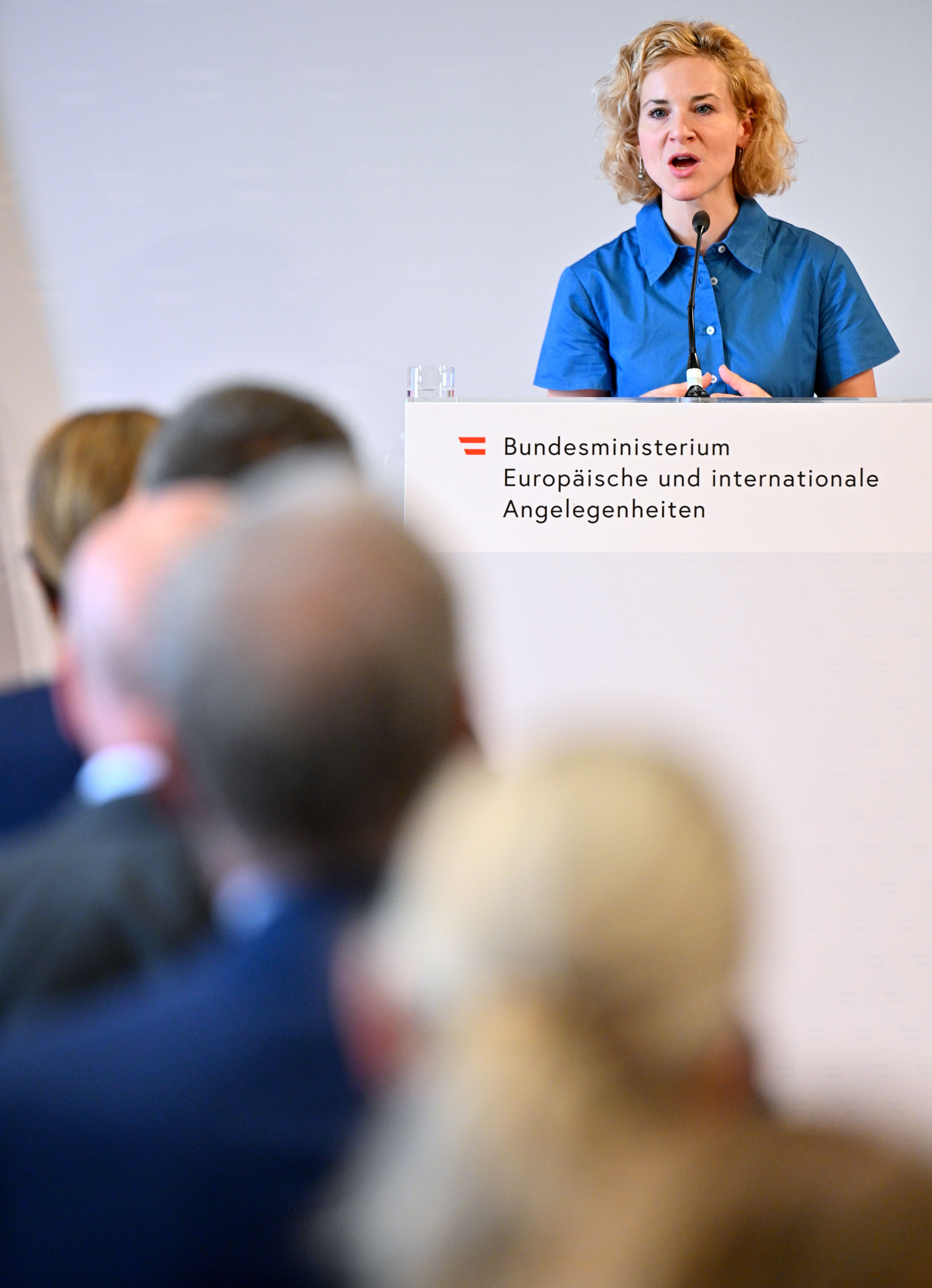Eine Frau spricht bei einer Veranstaltung des Bundesministeriums vor Publikum am Rednerpult.
