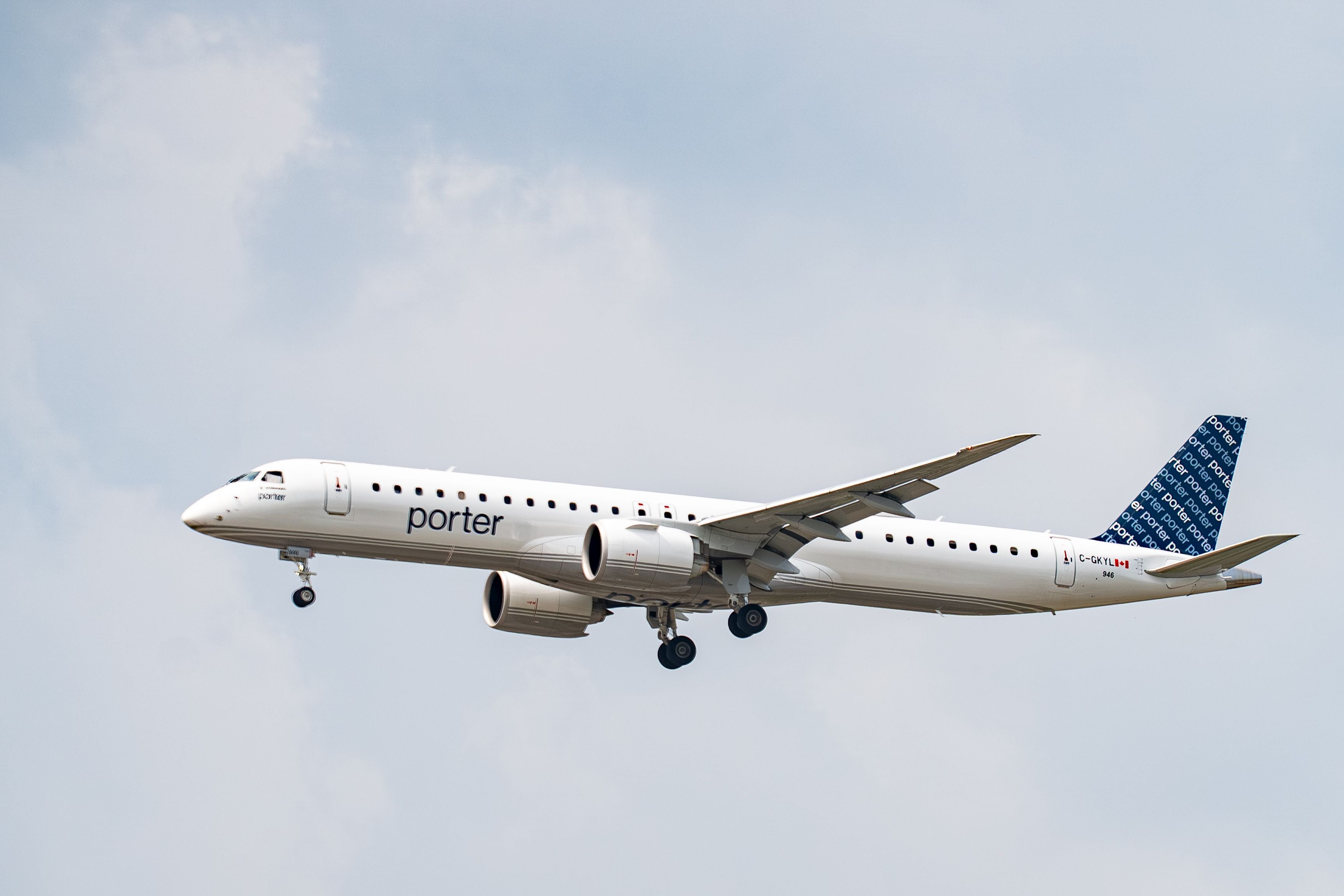 Flugzeug von Porter Airlines fliegt am Himmel mit ausgefahrenem Fahrwerk.