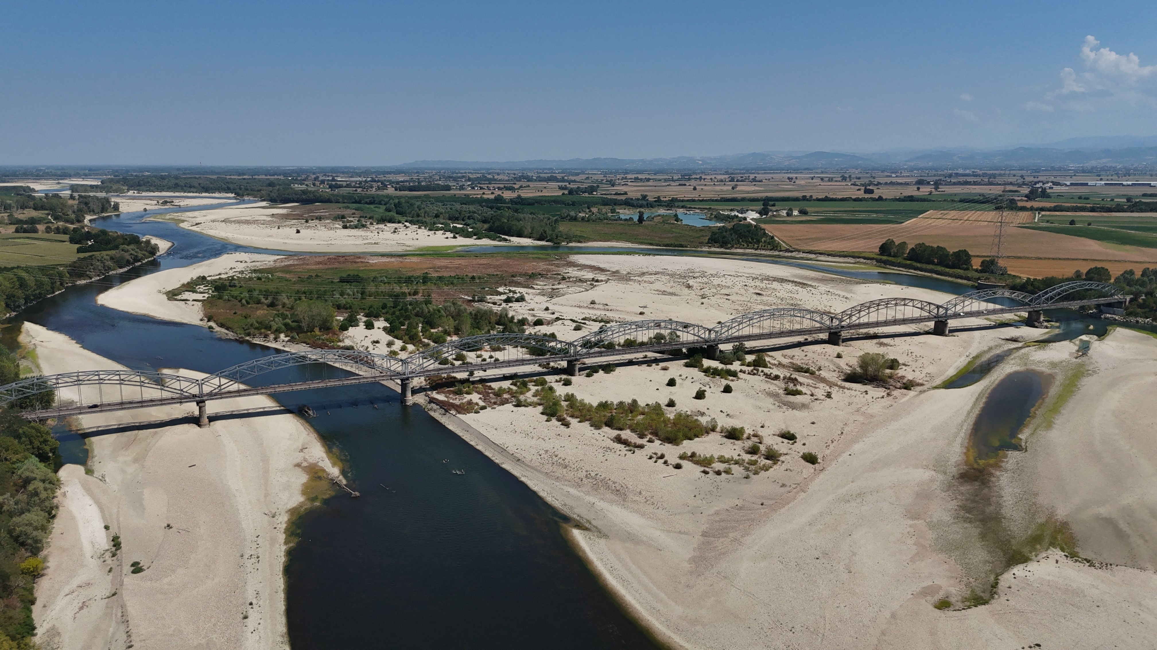Luftaufnahme der teils ausgetrockneten Po-Flusslandschaft mit Sandbänken und Brücke bei Mezzana Bigli.
