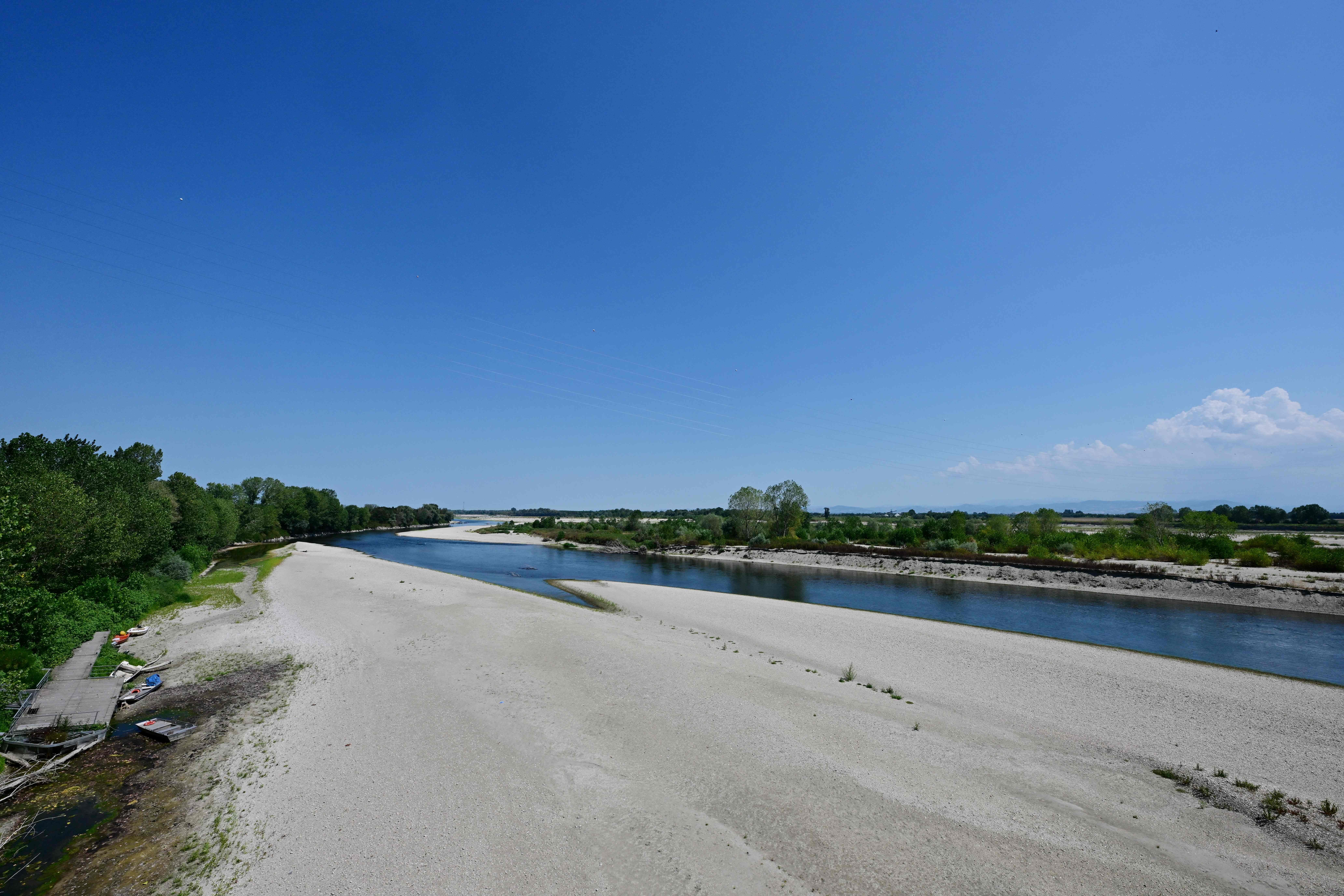 Sandbänke am Po-Fluss bei niedrigem Wasserstand in Mezzana Bigli, Norditalien, unter blauem Himmel.