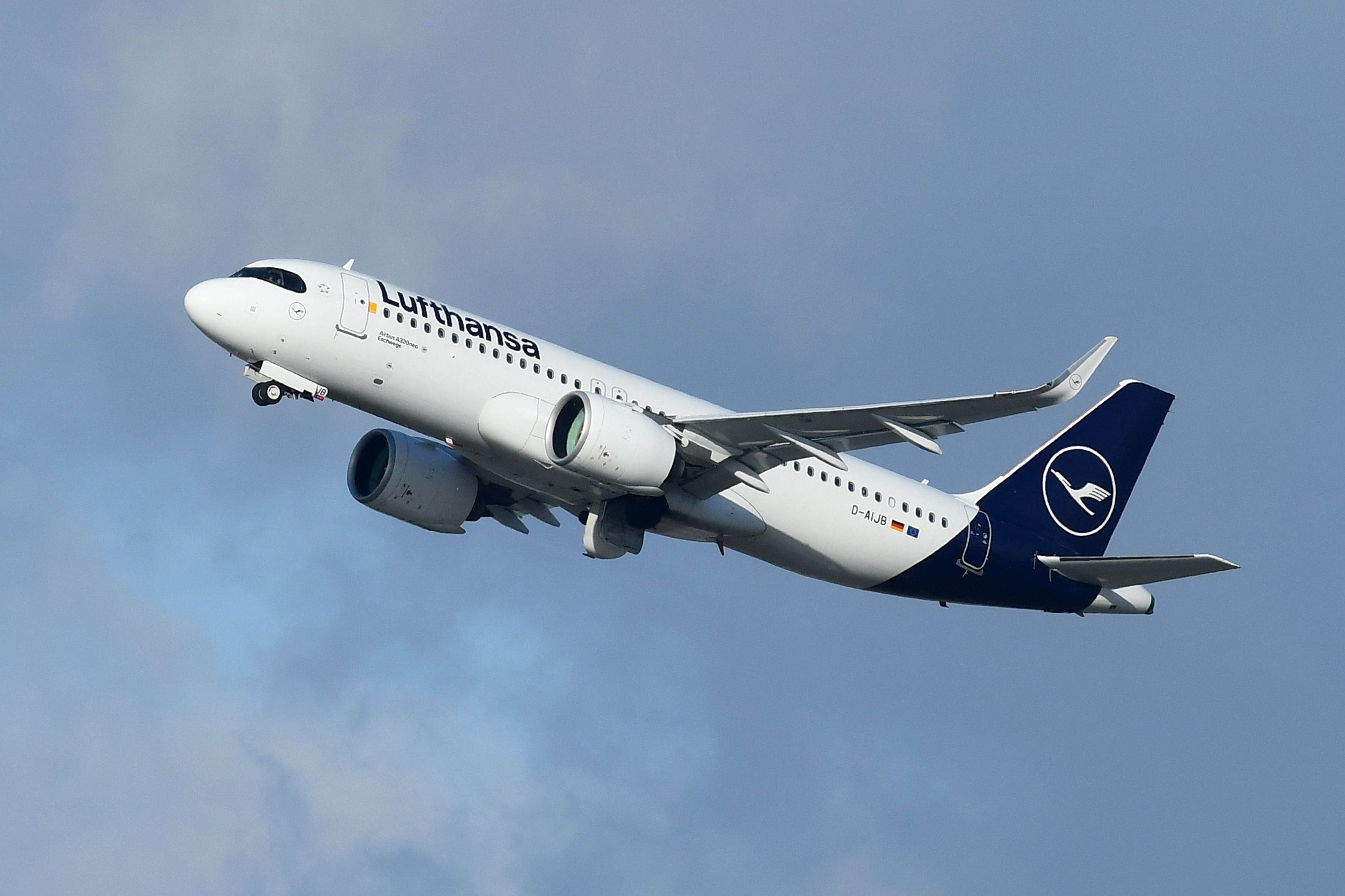 Ein Lufthansa Airbus A320Neo startet in den Himmel mit leicht bewölktem Hintergrund.