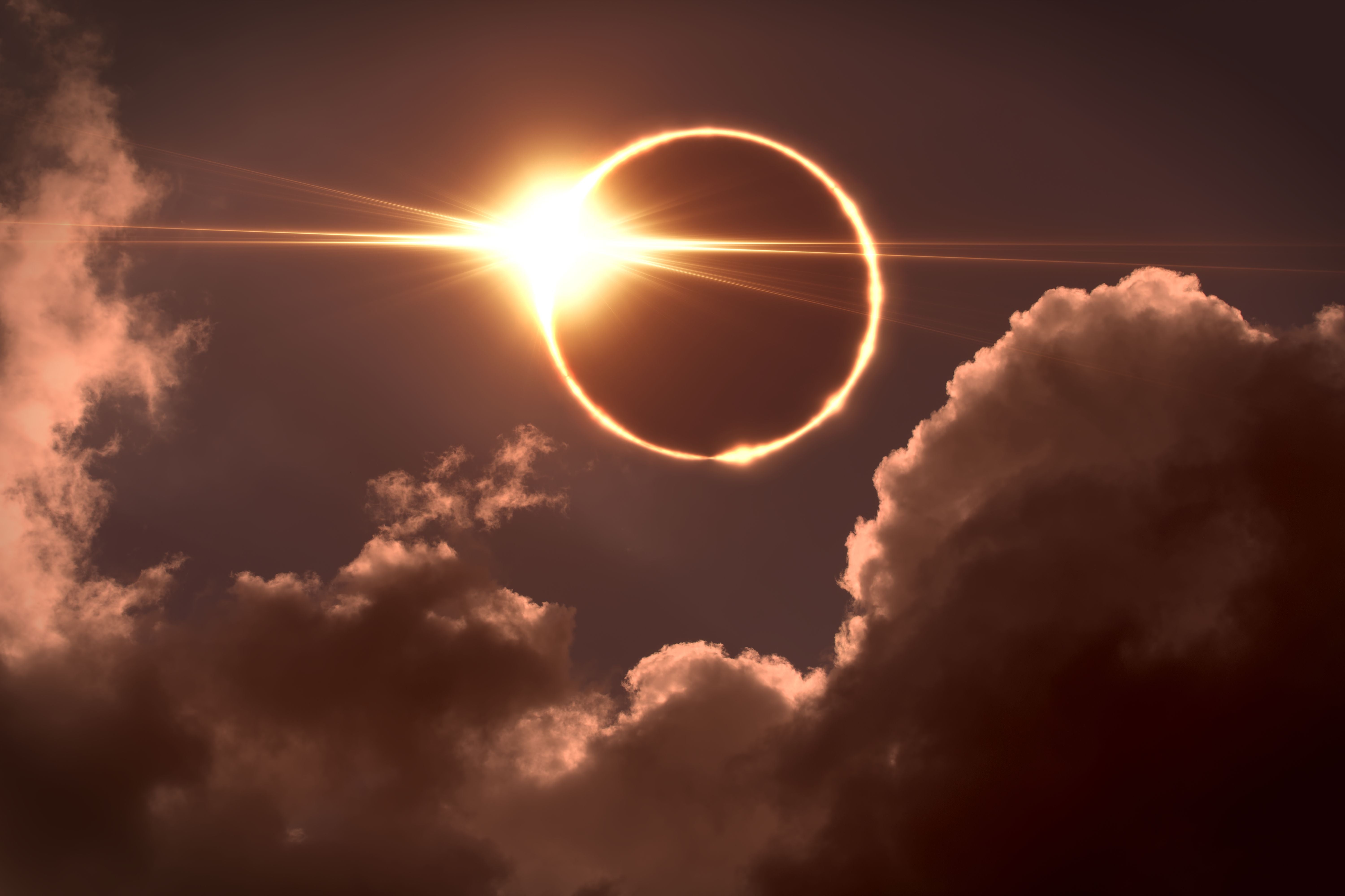 Sonnenfinsternis: Der Mond bedeckt die Sonne, helle Strahlen durchbrechen den dunklen Himmel.
