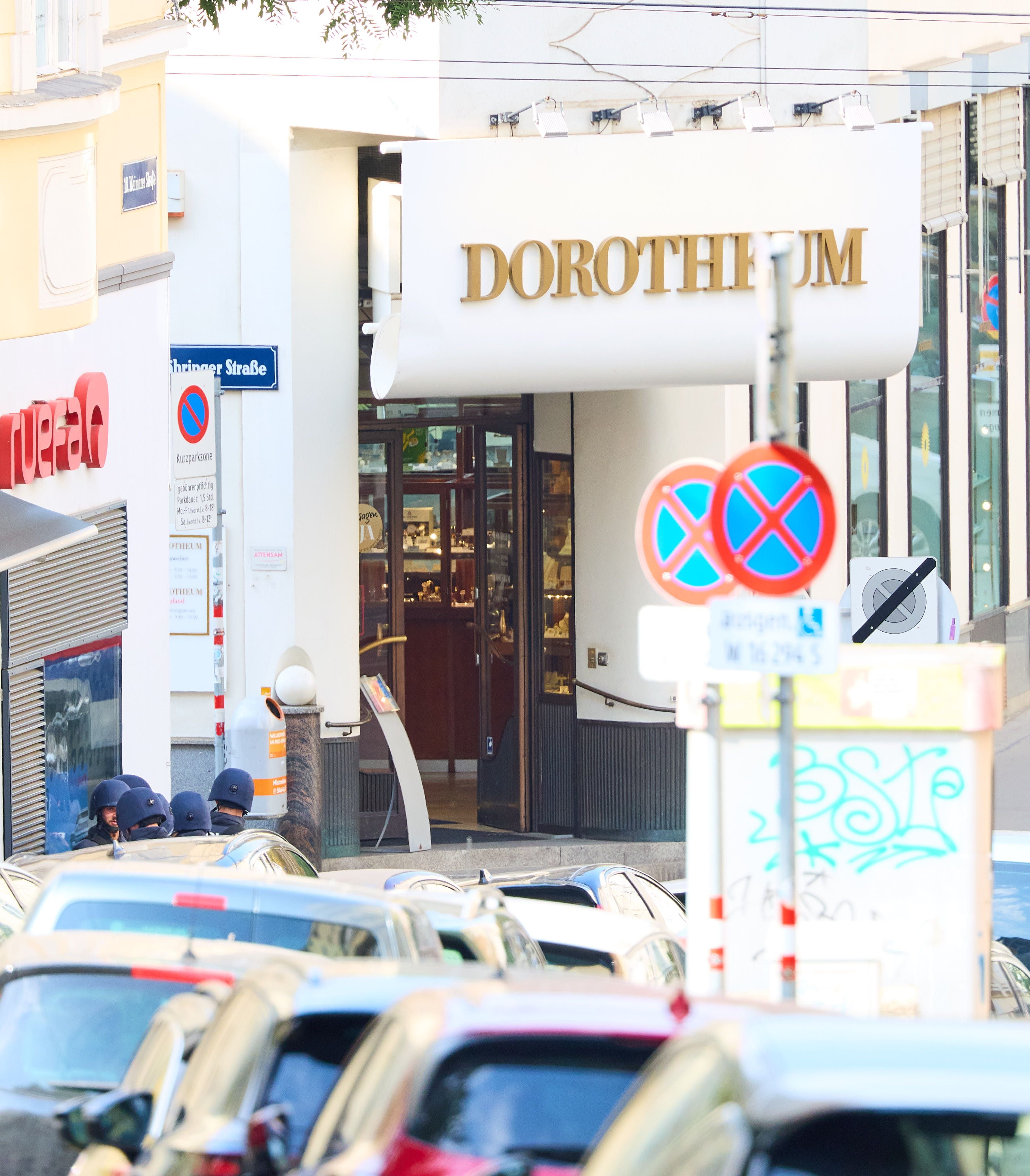 Polizeieinsatz vor dem Dorotheum in Wien mit mehreren Einsatzkräften und vielen parkenden Autos.