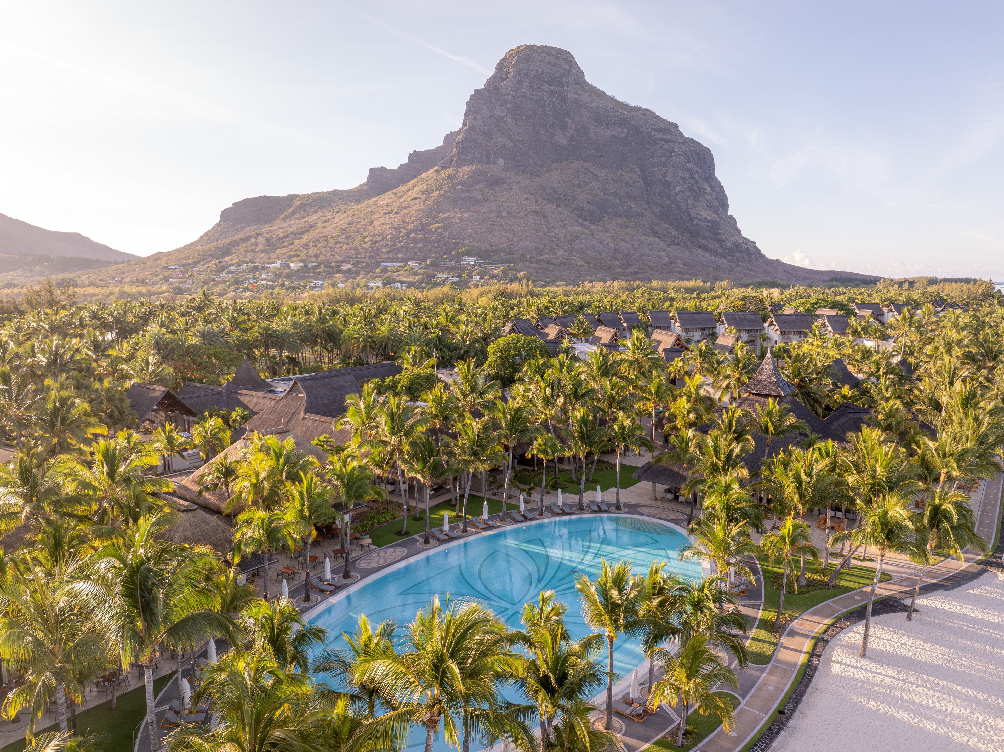 Großer Pool inmitten von Palmen vor dem Le Morne Brabant Berg auf Mauritius.
