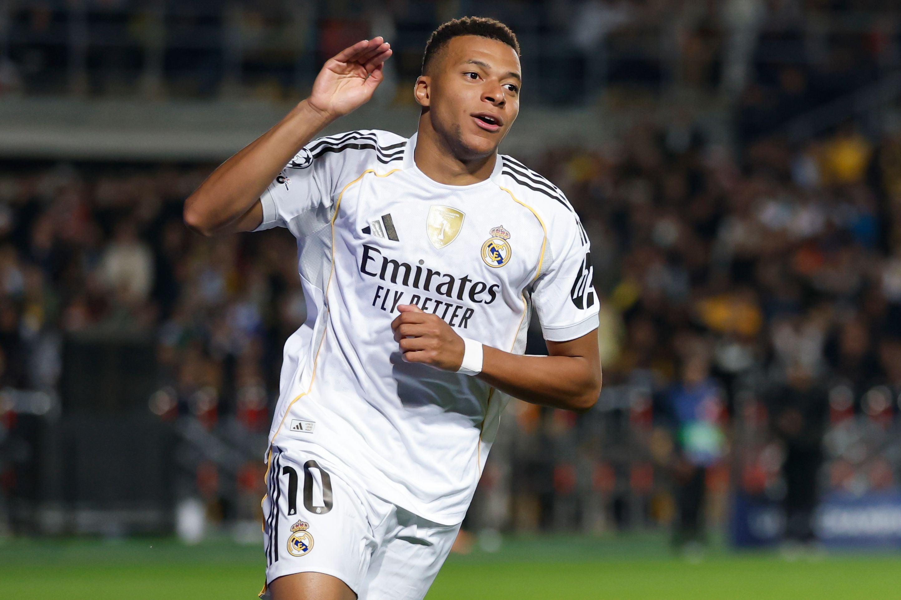 Fußballspieler im weißen Real-Madrid-Trikot jubelt nach einem Tor auf dem Spielfeld.