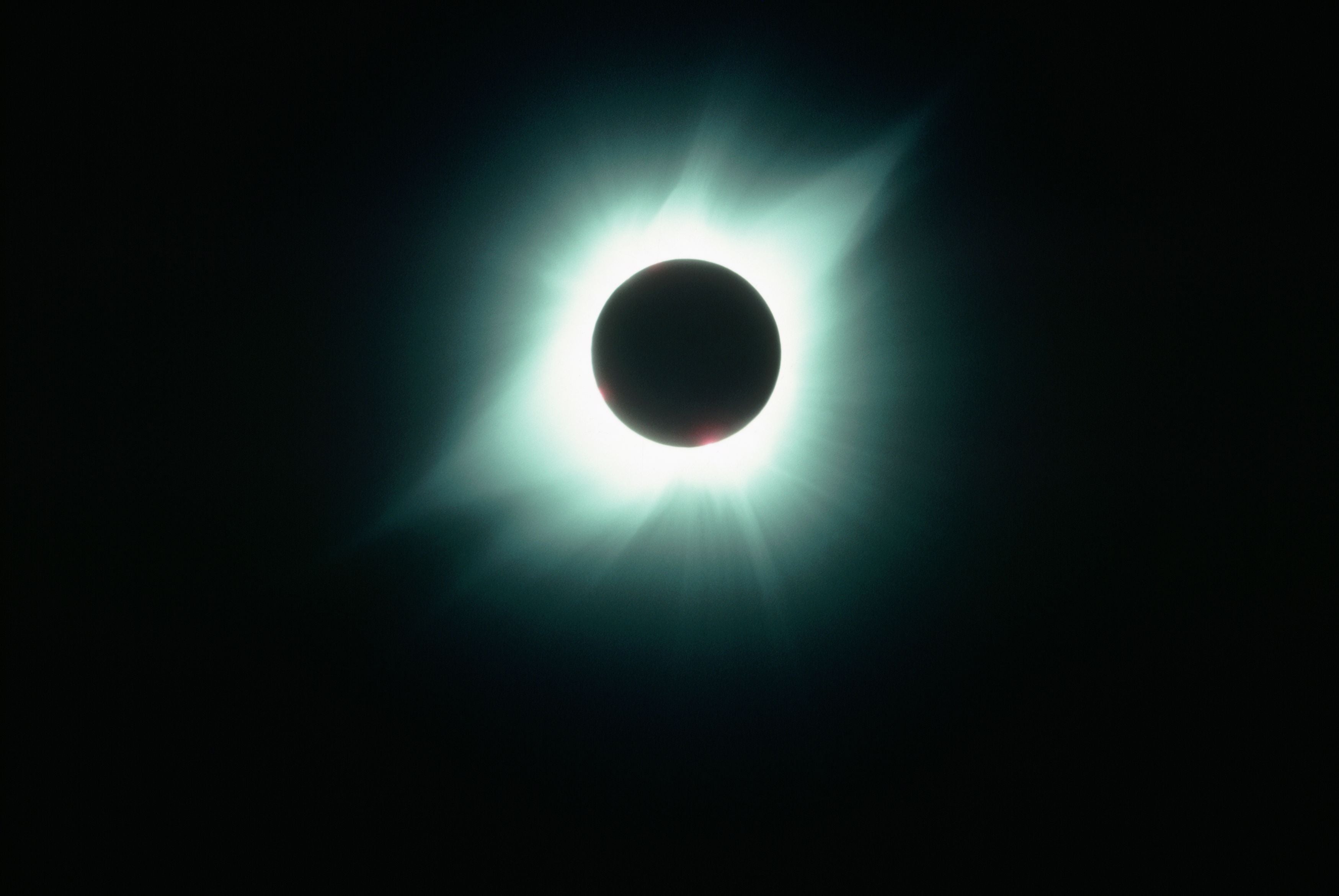 Totale Sonnenfinsternis mit leuchtender Korona um den verdunkelten Mond.