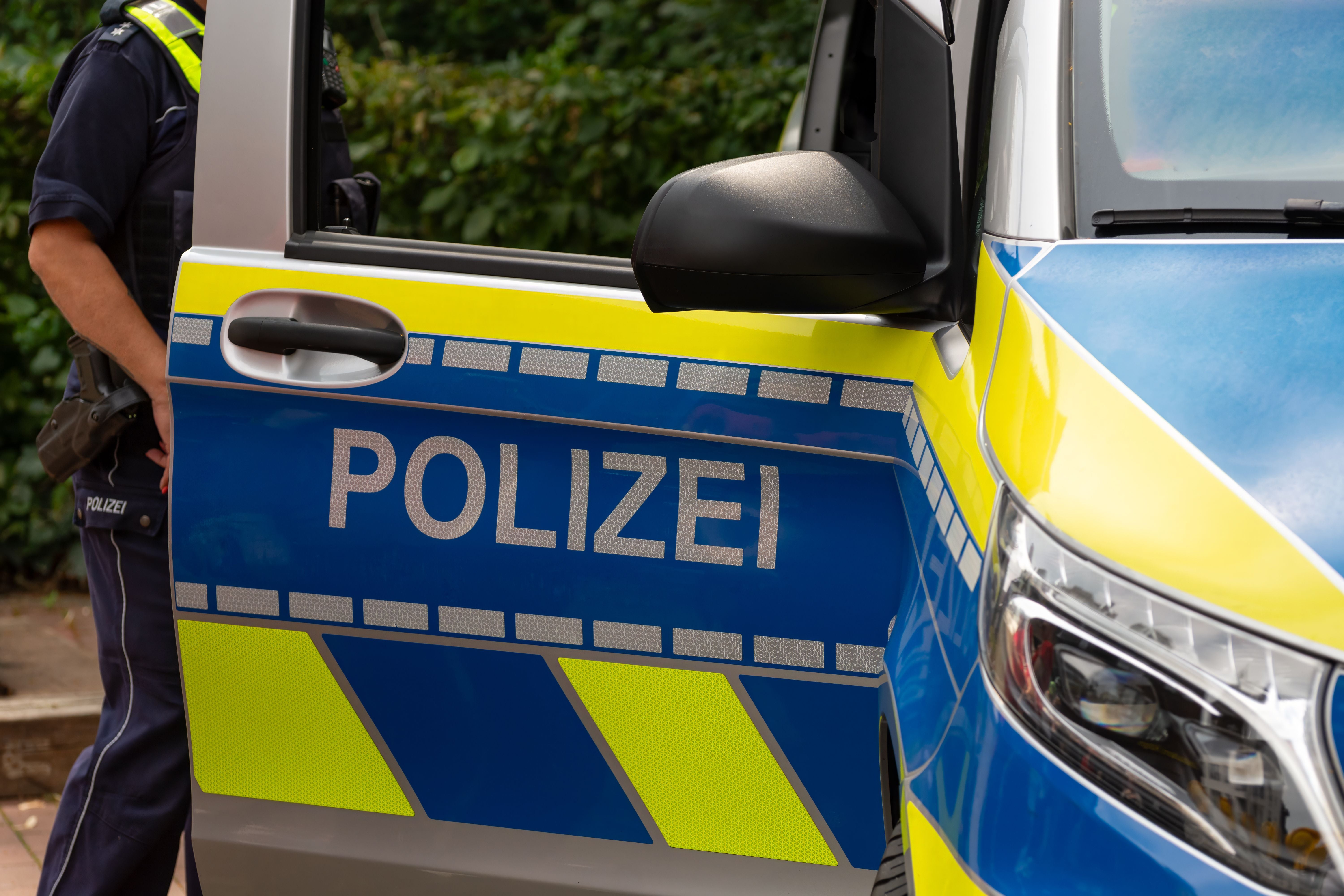 Offene Tür eines deutschen Polizeiautos mit dem Schriftzug „Polizei“.