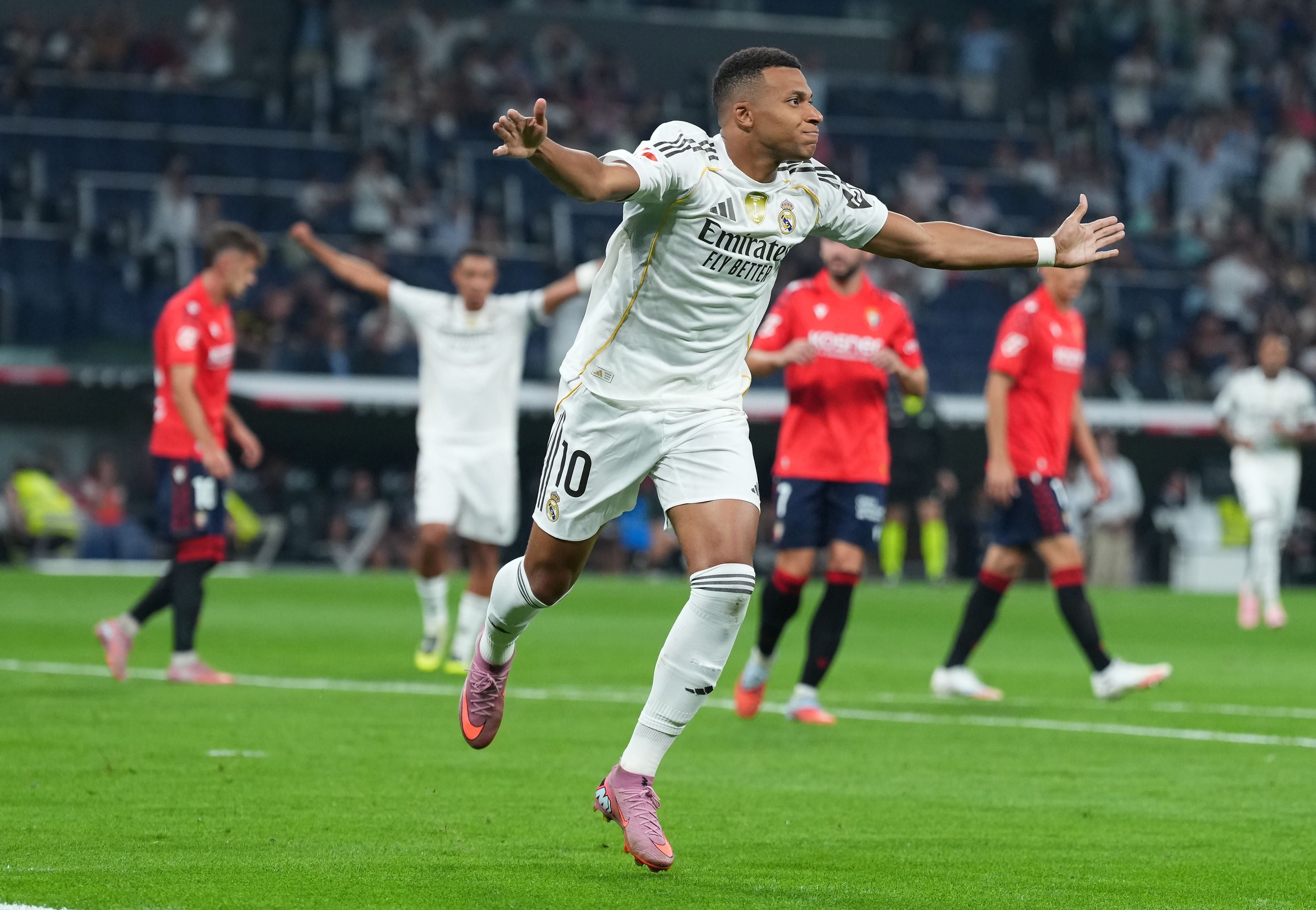 Ein Real-Madrid-Spieler jubelt nach einem Tor im Stadion, andere Spieler im Hintergrund.