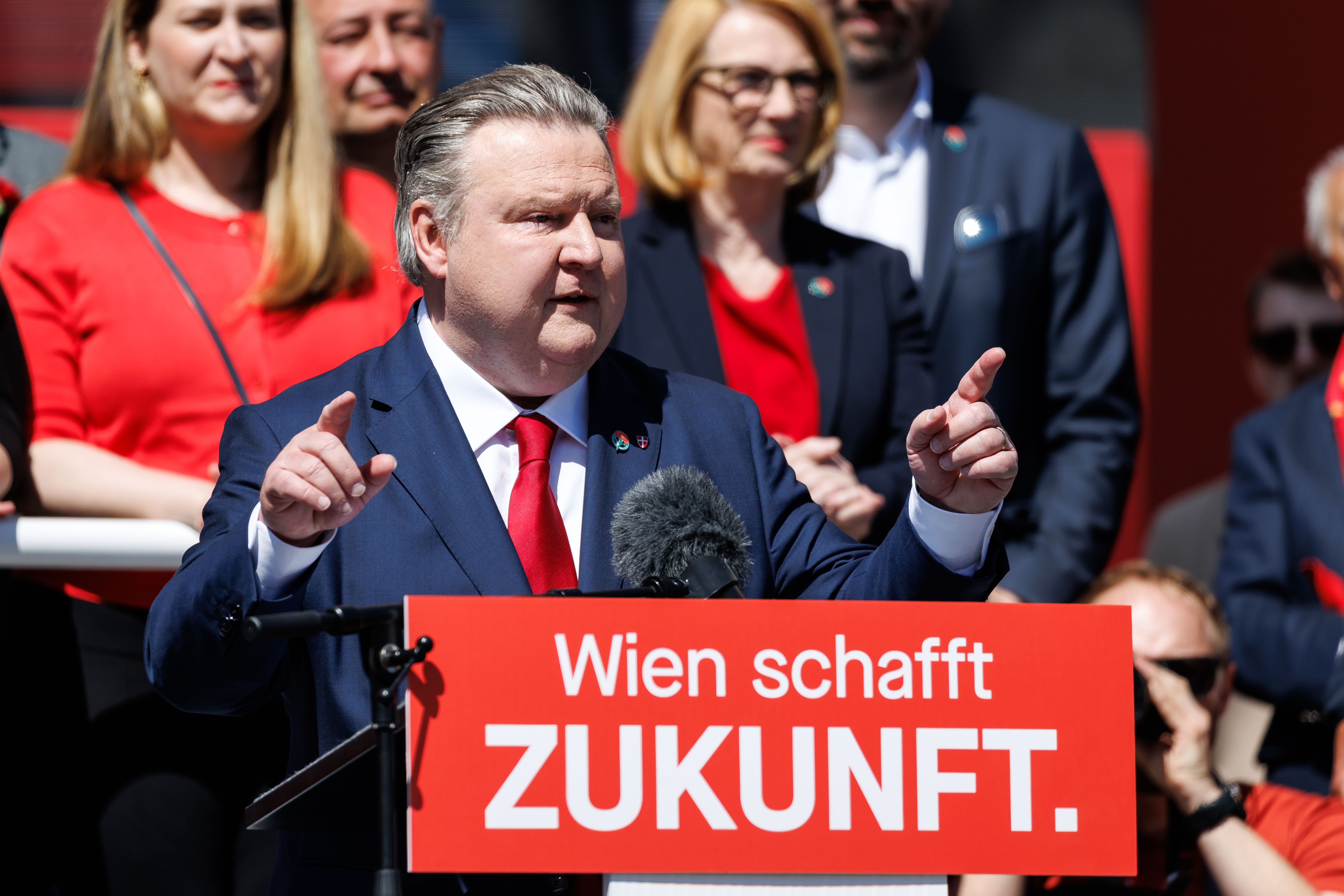 Ein Mann im Anzug spricht bei einer Kundgebung am Rednerpult mit Schild „Wien schafft ZUKUNFT.“