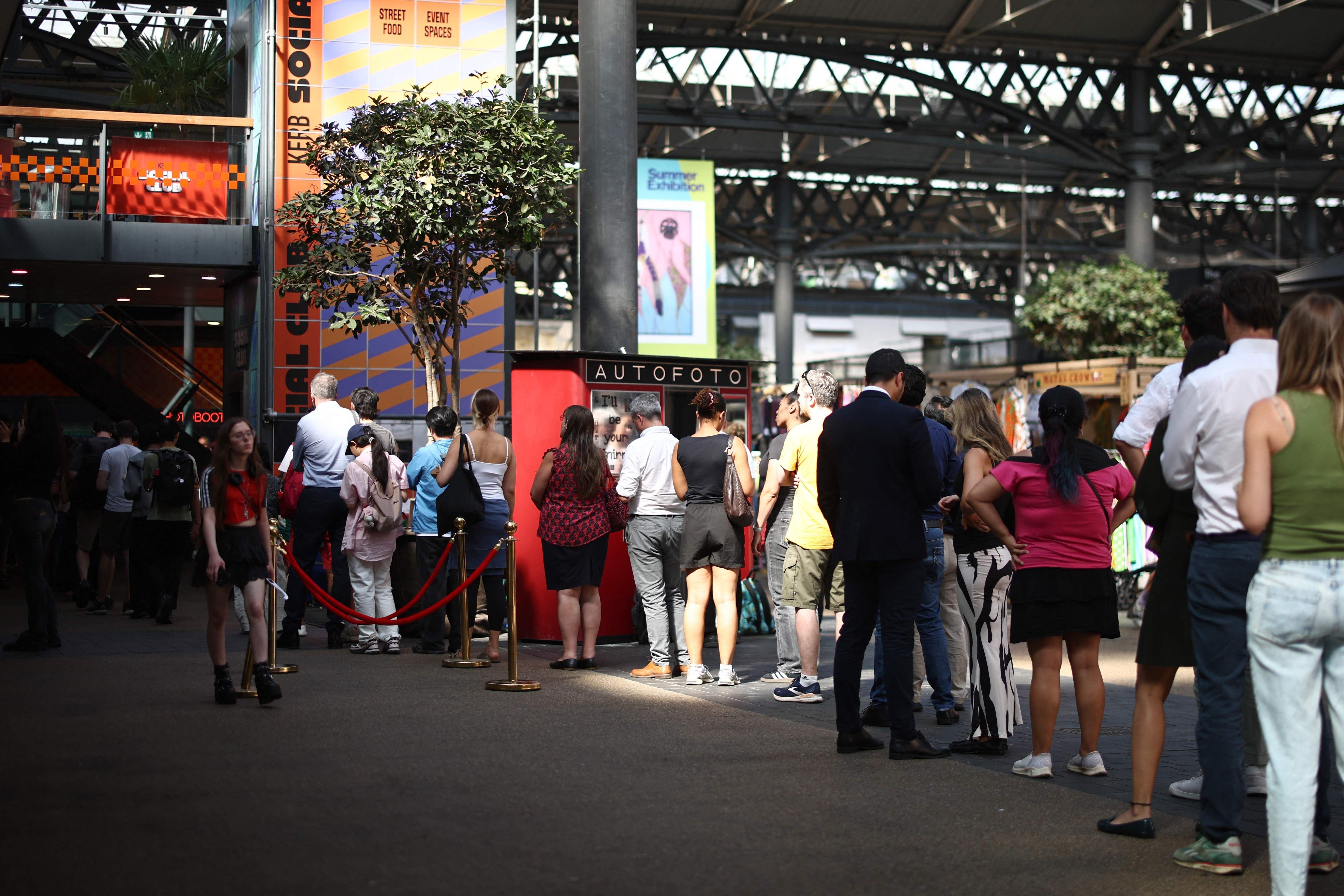 Menschen stehen in einer langen Schlange in einer Markthalle, um Sonnenfinsternisbrillen zu kaufen.