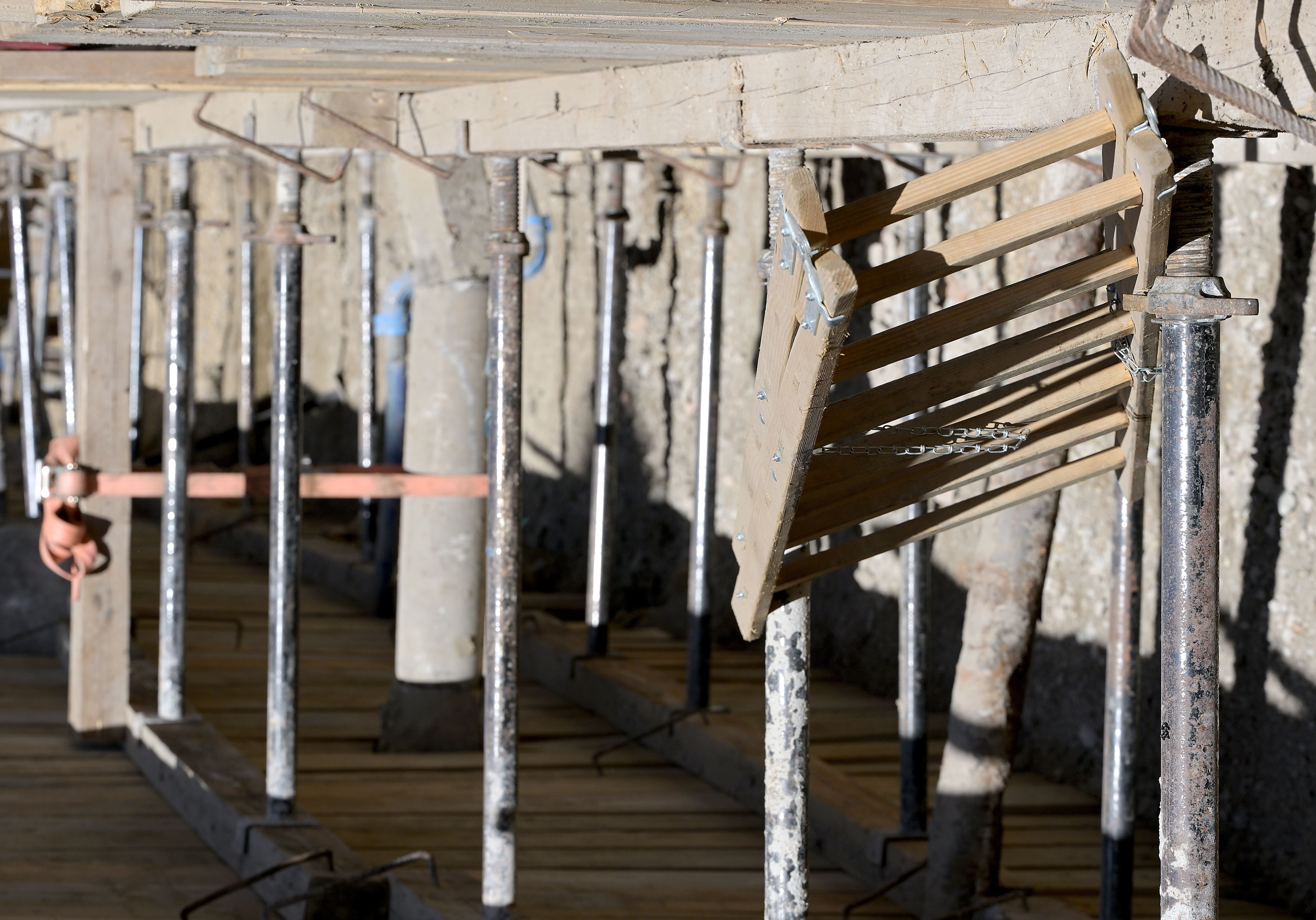 Bauarbeiten mit Holzverschalung und Stützpfeilern auf einer archäologischen Ausgrabungsstätte.