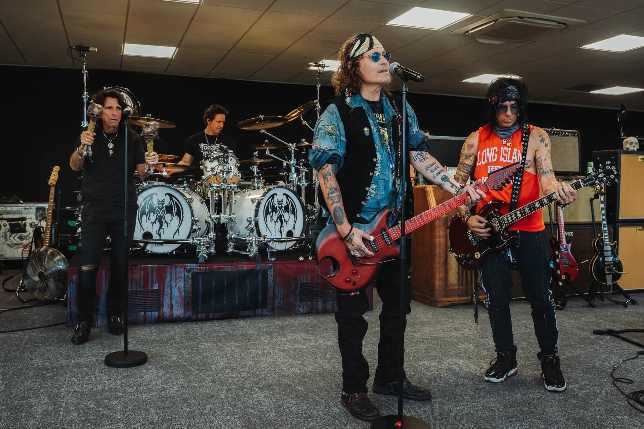 Die Band Hollywood Vampires probt mit Mikrofonen, Gitarren und Schlagzeug auf einer Bühne.