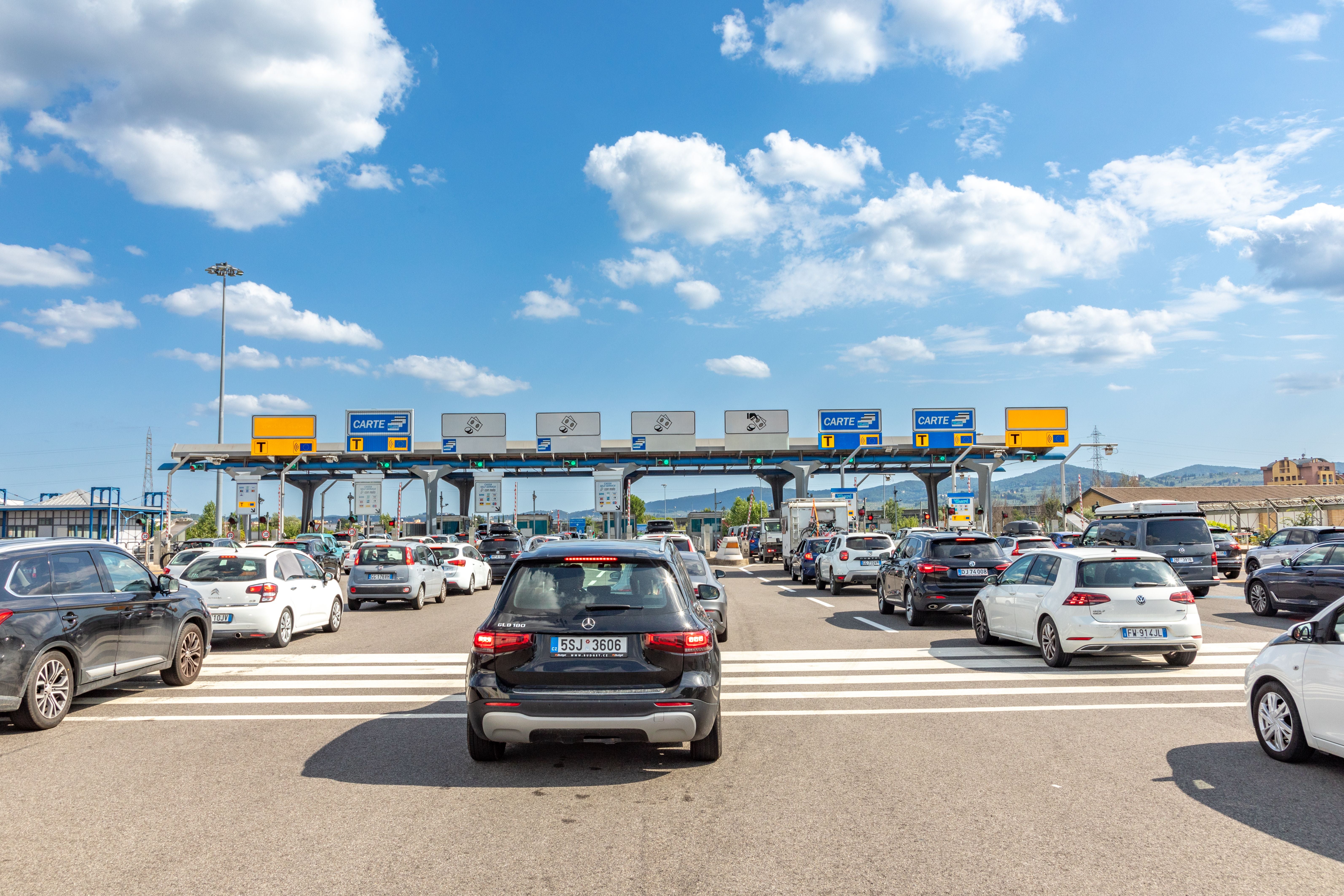 Stau vor einer Mautstation auf der Autobahn bei Florenz, Italien bei sonnigem Wetter.