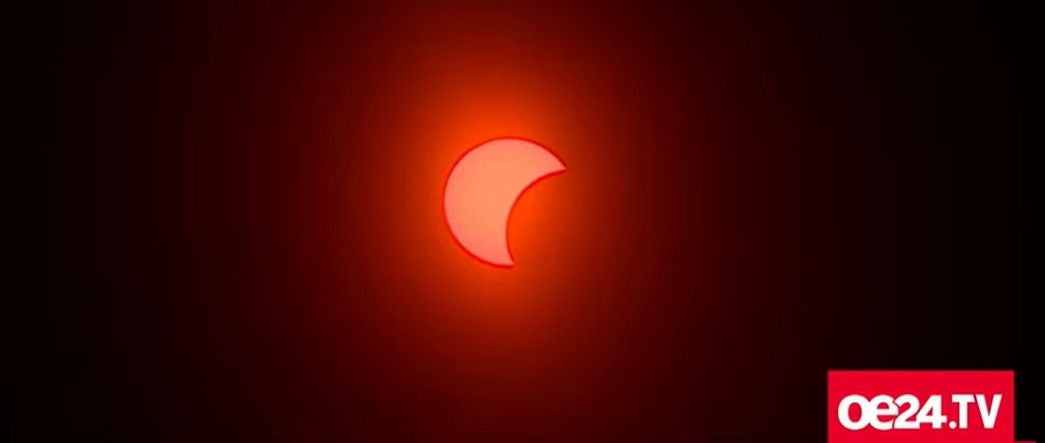 Teilweise Sonnenfinsternis mit rotem Lichtschein, fotografiert in Wien.