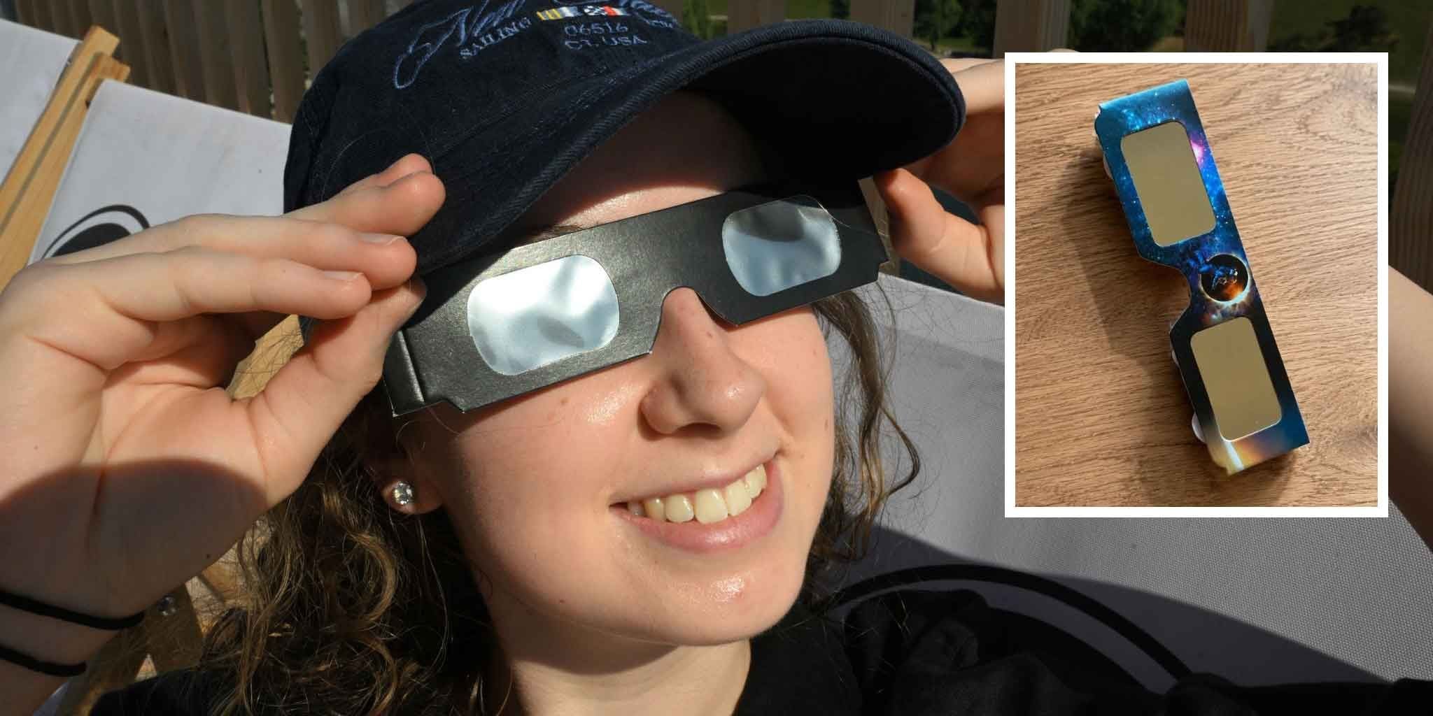Eine Frau trägt eine Sonnenfinsternisbrille; daneben eine Brille als Nahaufnahme auf einem Tisch.
