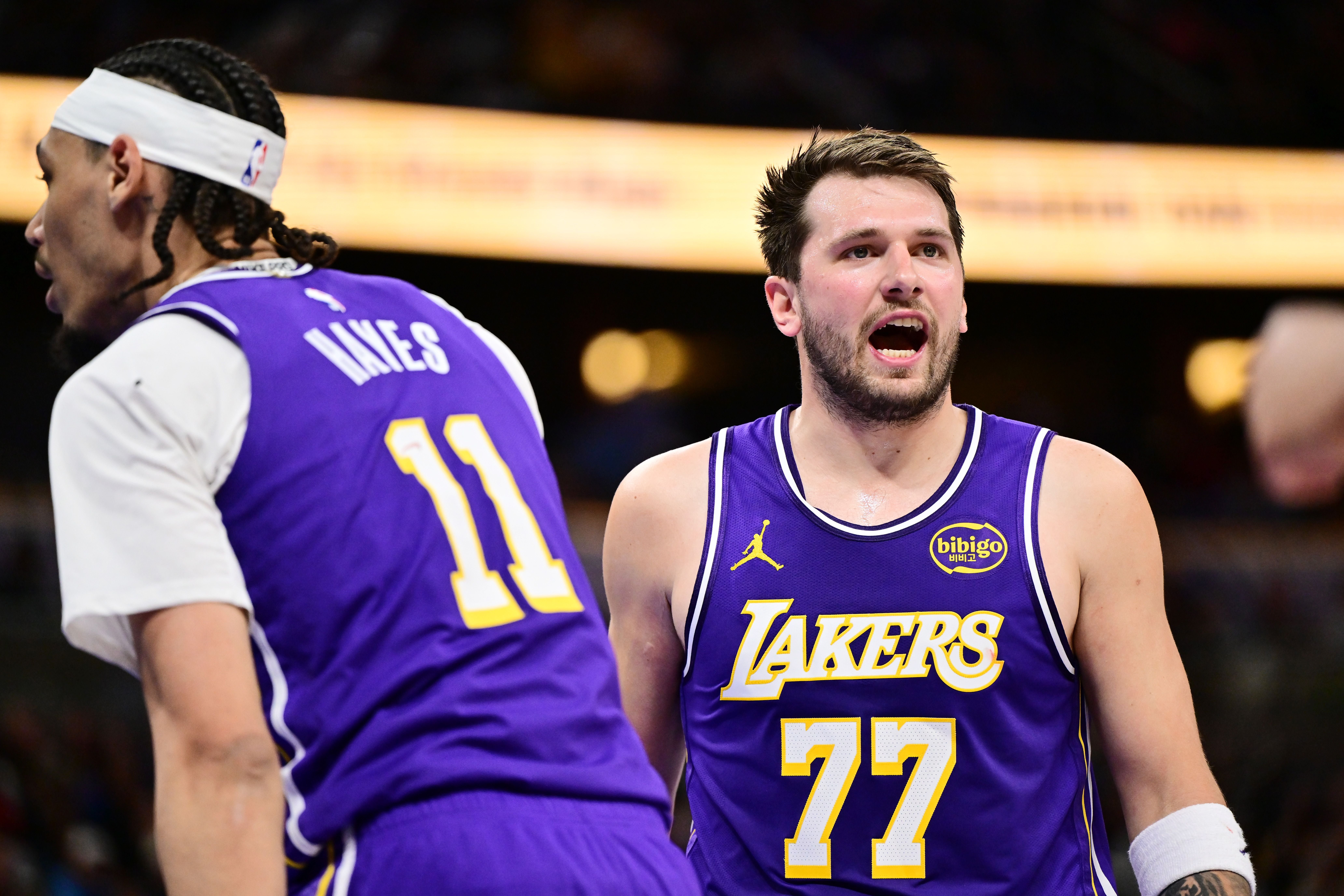 Zwei Basketballspieler der Lakers im Spiel, einer mit der Nummer 77, sichtbar am Jubeln.