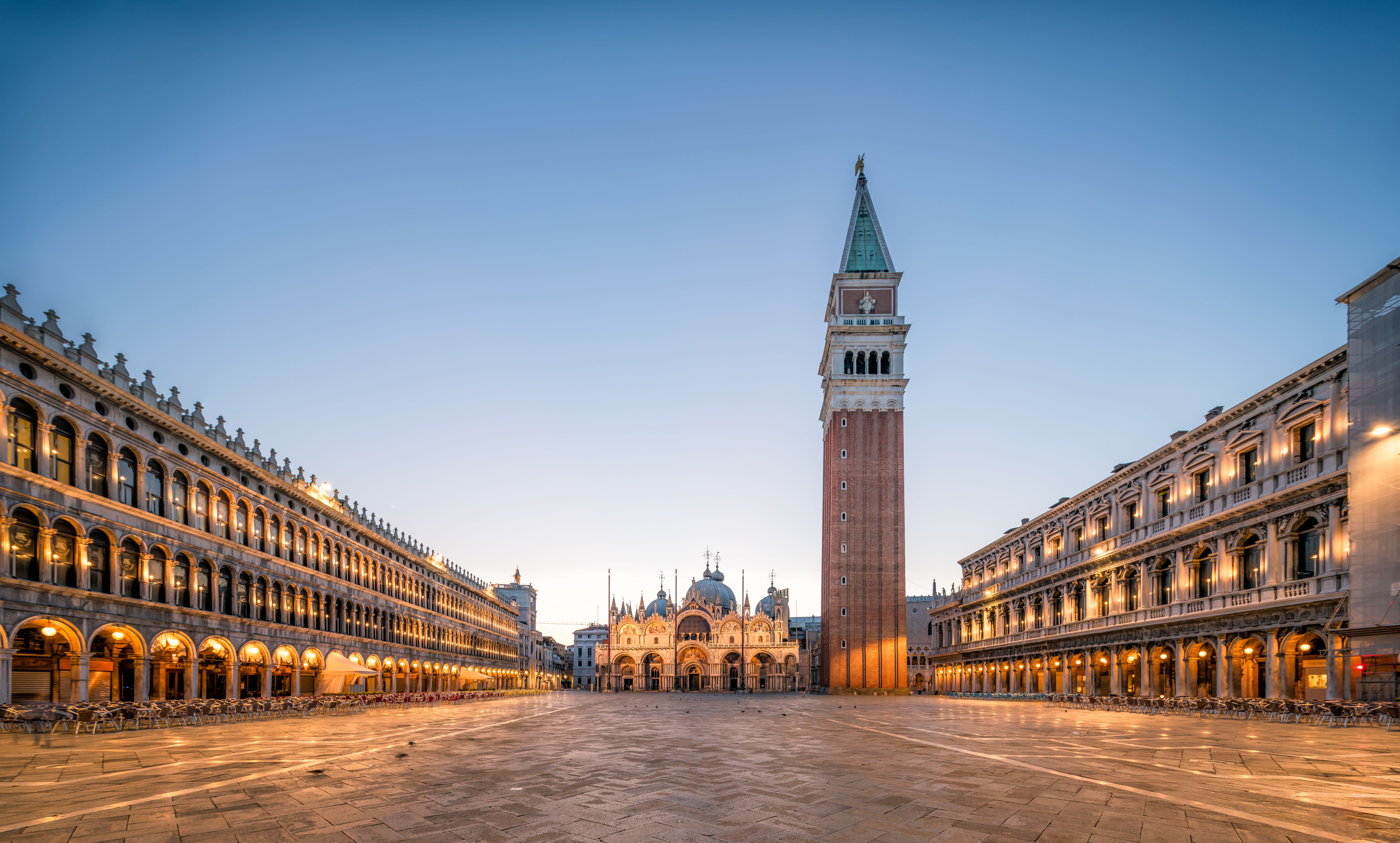 Leerer Markusplatz in Venedig am Morgen mit Markusdom und Campanile im Hintergrund.