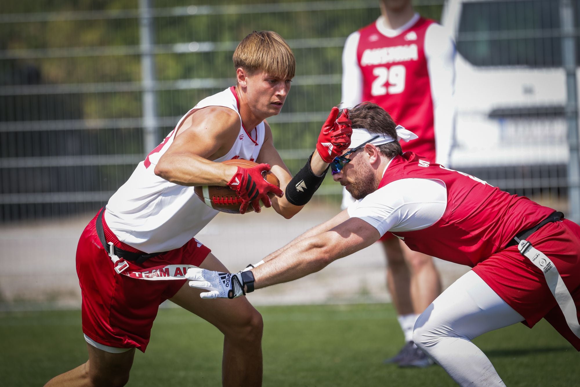 Zwei Flag Football-Spieler kämpfen um den Ball auf einem Spielfeld.